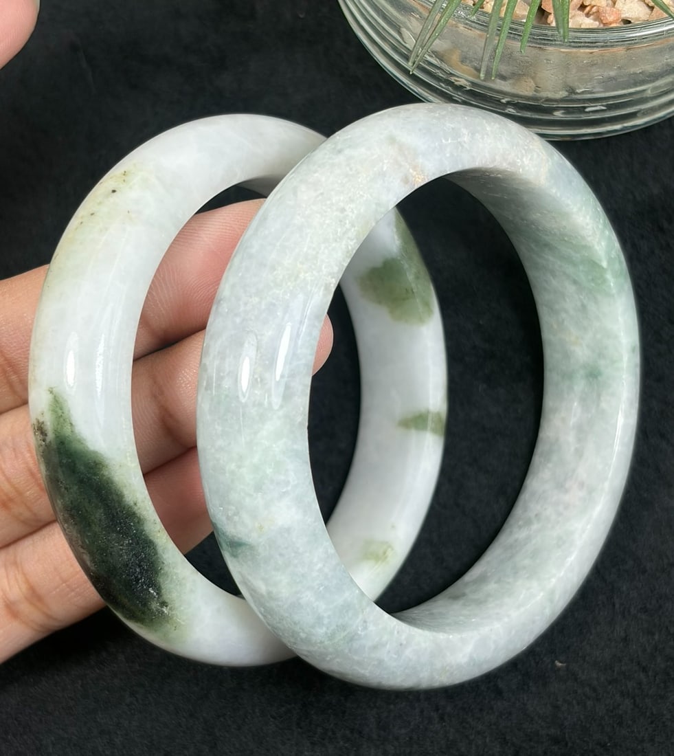 Lot of 2 Natural Burmese Type A Floating Green Jadeite Bangles, 53mm & 56.4mm Inner Diameter, 34AV: Pair of untreated Type A jadeite bangles with inner diameters 53mm and 56.4mm, smooth polished white jade bases naturally dotted with scattered dark moss green floating mineral inclusions, solid wide 