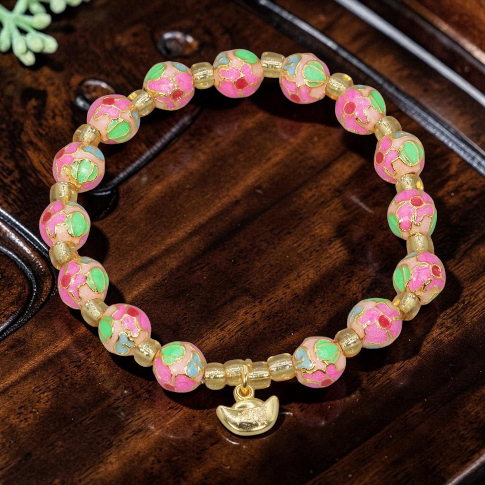 A Chinese Cloisonne Enamel Beaded Bracelet - Pink Gold-Tone Ingot Charm, 44YJ: This modern Chinese-style bracelet features 7.8mm round cloisonne enamel beads in a soft pink hue, each detailed with raised gold-tone floral patterns accented with green, blue, and red enamel. Small 