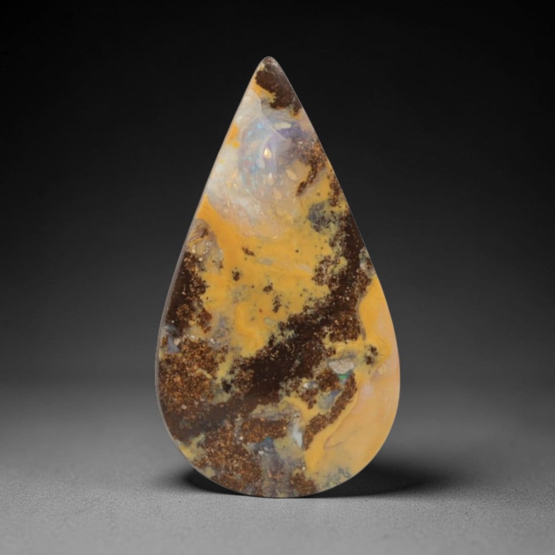 9.14 Carats Golden Landscape Boulder Opal Teardrop Cabochon - Natural Australian Stone, 13XC: This evocative boulder opal cabochon, measuring 20.7 x 11.5 x 4.6 mm, presents a striking natural scene captured in stone. Polished into a graceful teardrop shape, the stone features a rich tapestry o