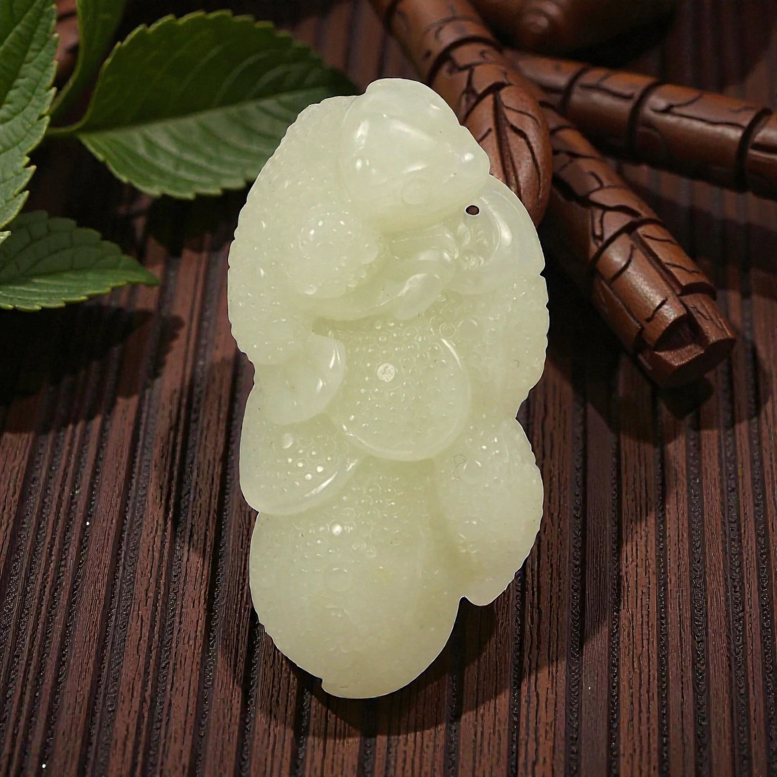 A Chinese Jade Beast and Fruit Carving, 20th Century, 78FA: Carved from pale green to light yellow jade with areas of translucency and scattered natural inclusions, the object represents a stylized beast crouched upon a fruiting form. The creature is rendered 