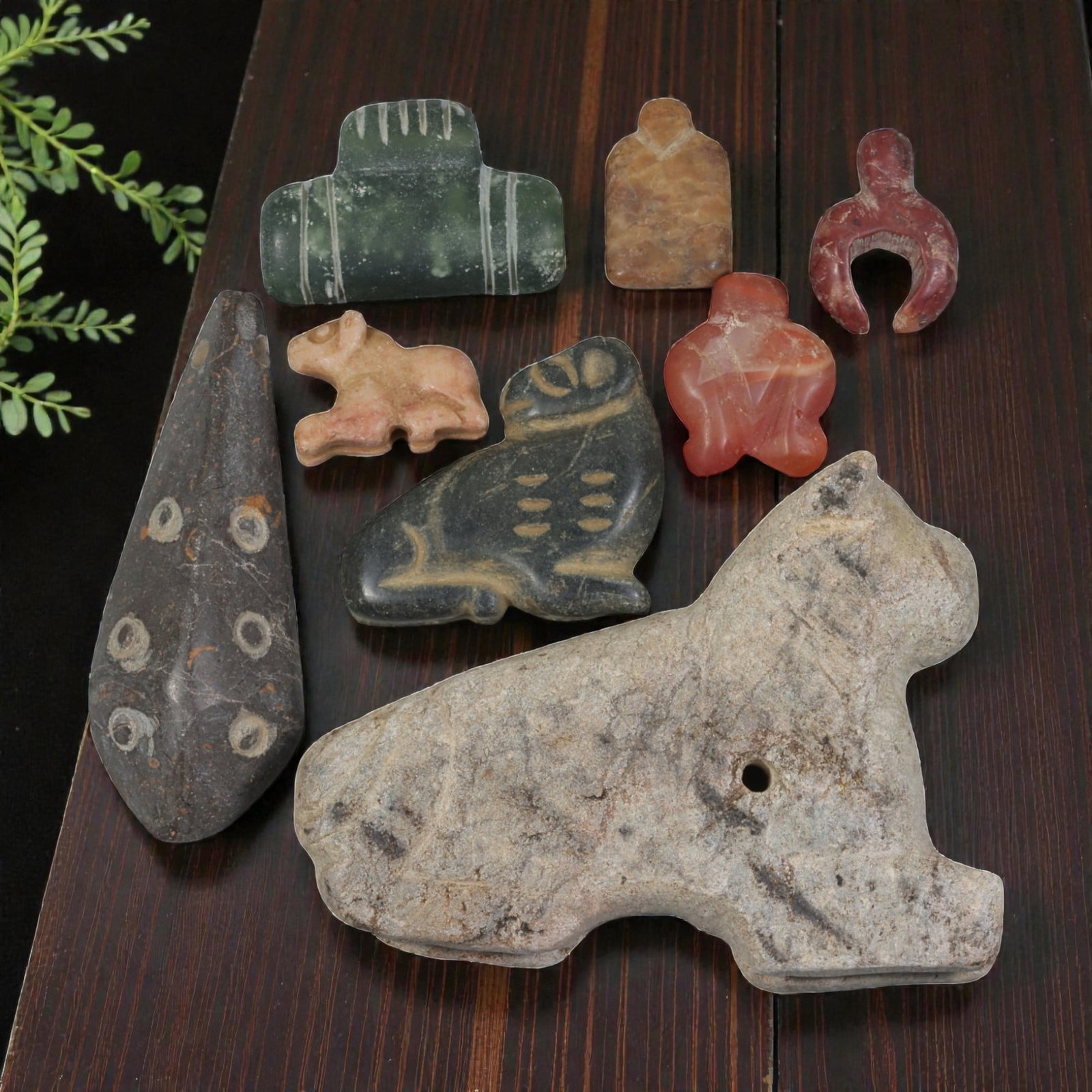 Lot of 8 Ancient Near Eastern Multi-Stone Amulets, 90AH: Carved from a diverse range of materials including green serpentine, brownish stone, red carnelian, pink marble, dark grey stone, and light grey stone, the group consists of eight distinct amulets, ra