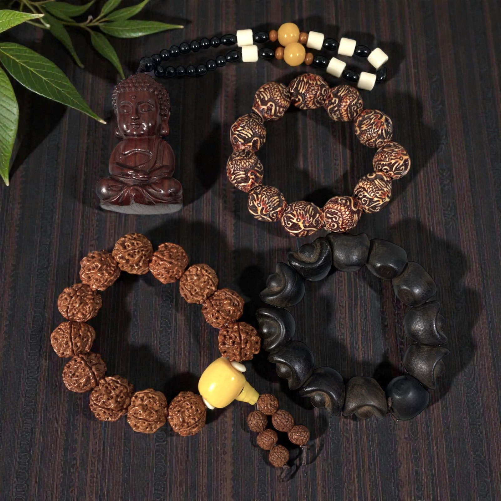 Lot of 4 Vintage Oriental Chinese Wood and Seed Bead Bracelets, 65AG: The group consists of four vintage bracelets and one pendant strand crafted from wood and seeds. The top-left strand features a carved dark wood seated Buddha pendant suspended from alternating black,