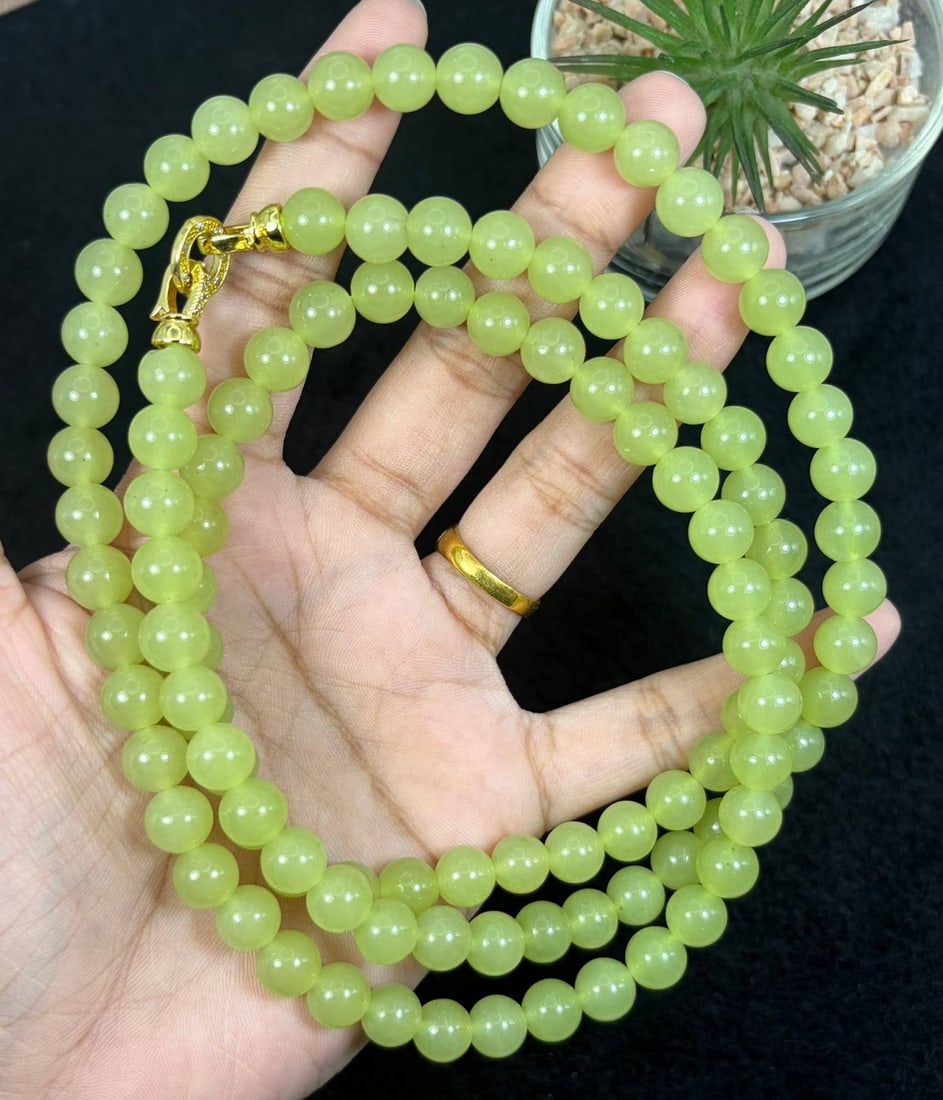 Natural Qinghuangkou Hetian Jade Round Bead Necklace, 2YM: This elegant necklace features smooth, polished round beads of natural Qinghuangkou Hetian jade, strung with a secure gold-toned clasp. The jade exhibits a delicate, warm yellow-green hue, characteris