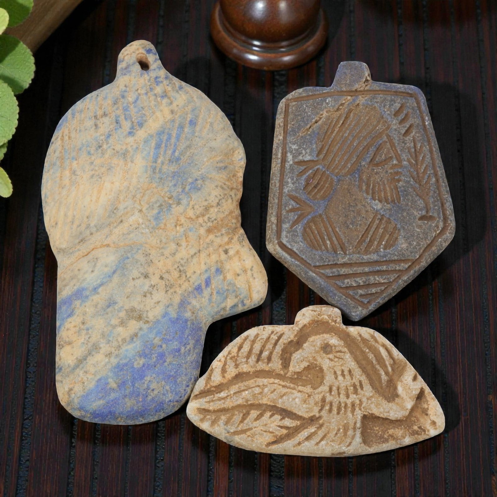 Lot of 3 Ancient Near Eastern Lapis Lazuli and Stone Amulets, Circa Iron Age, 6AE: The group comprises three amulets, including two lapis lazuli examples and one stone example, each with a suspension loop for wear. The first is a large hand-shaped lapis lazuli amulet, with incised p