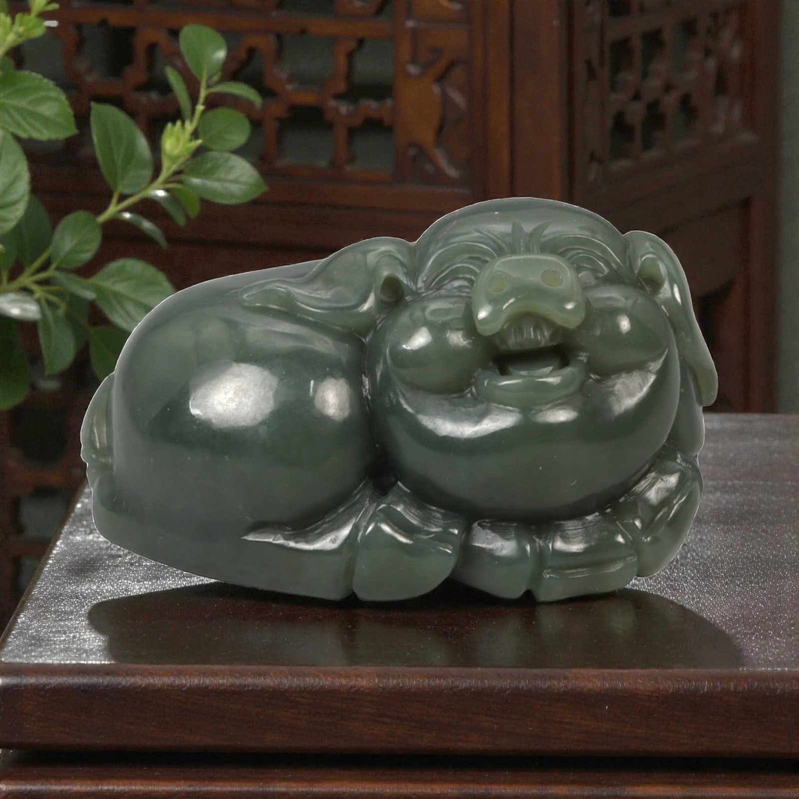 A Chinese Nephrite Jade Pig Figure, 20th Century, 92YA: Carved from dark green nephrite jade with subtle tonal variation and a high-polished surface, the figure represents a recumbent pig shown in a compact, rounded posture. The head is rendered with a bro