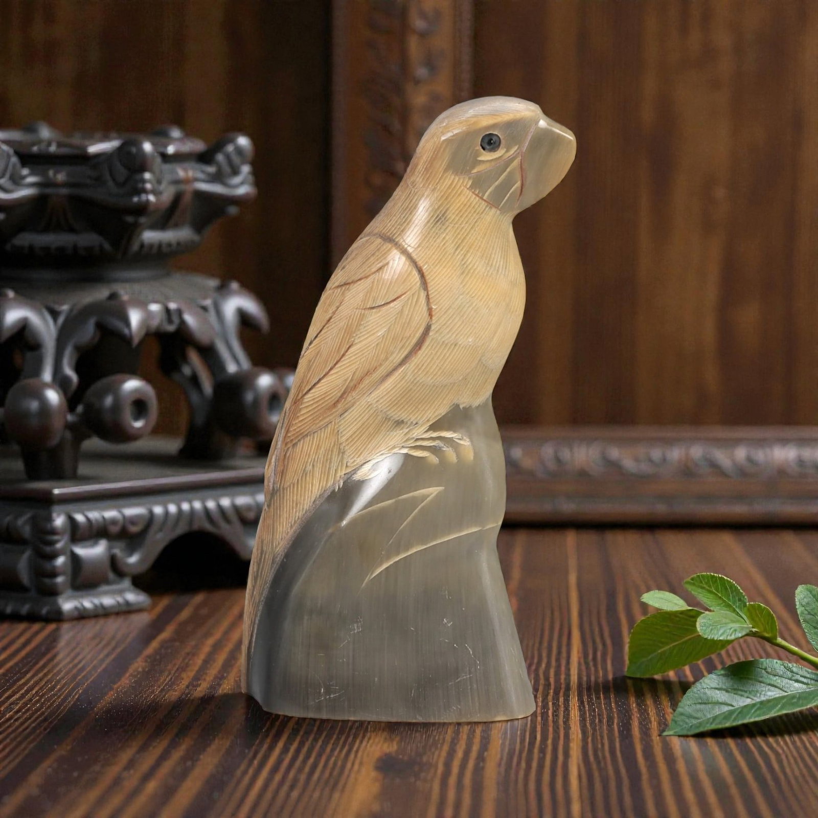 An East Asian Ox Horn Parrot Effigy, 20th Century, 11FJ: Carved from a single section of ox horn with visible natural striations and tonal variation from pale honey to translucent gray-brown, the effigy is modeled as a standing parrot rendered in the round.