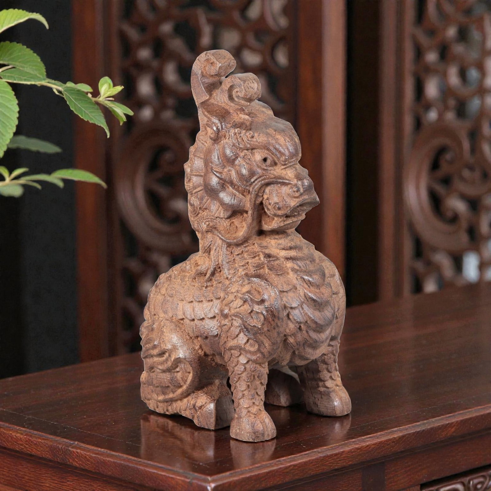 A Chinese Agarwood Qilin Figurine, 20th Century, 69FC: Carved from agarwood with natural tonal variation and a warm, deep brown patina, the figurine depicts a seated qilin (mythical auspicious beast). The creature is rendered in the round, with a detailed