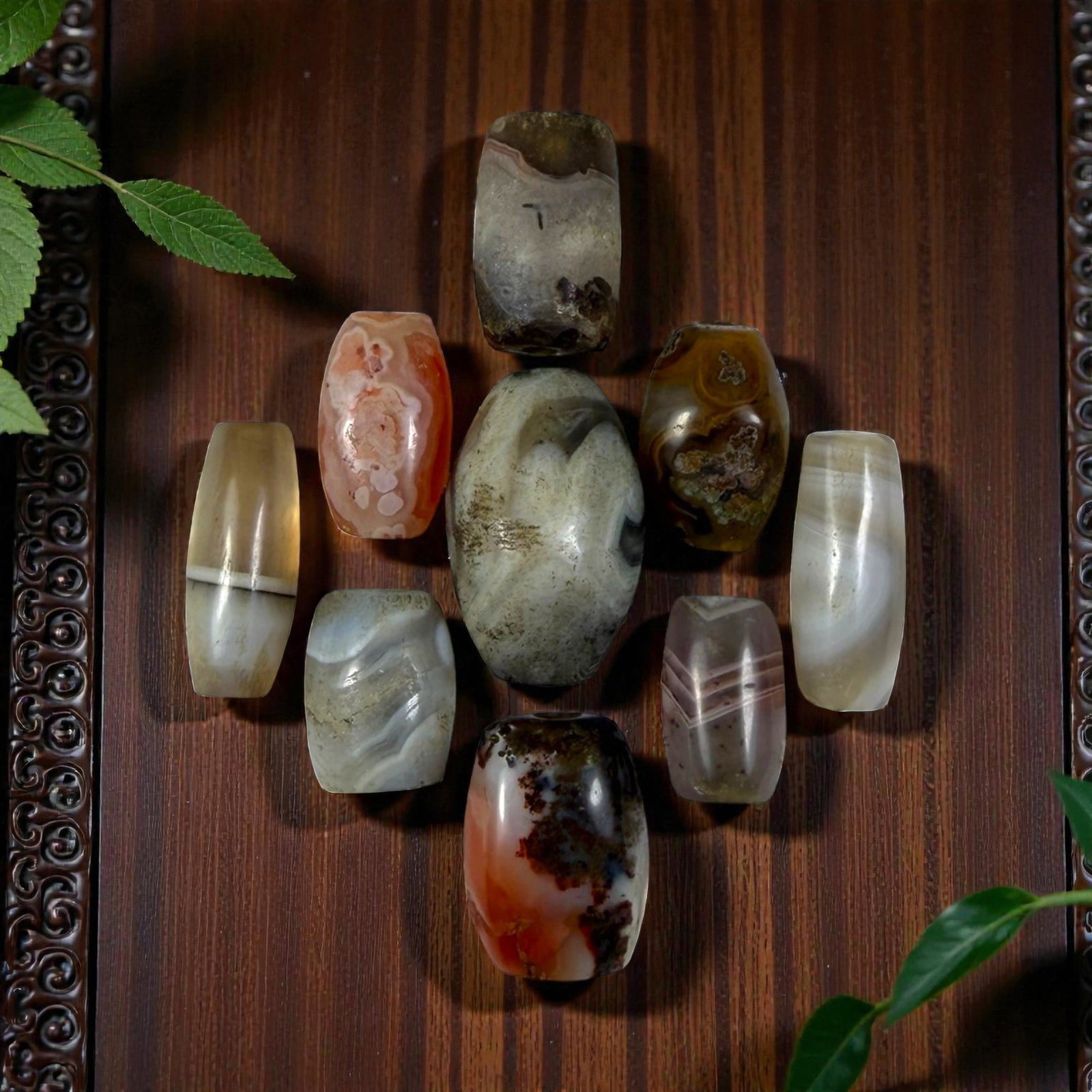 A Lot of 9 Himalayan Banded Agate Beads, Ancient to Antique Period, 29YD: Comprising lot of barrel and ovoid beads, each carved from banded agate with natural tonal variations, many displaying characteristic concentric, linear, and dendritic patterns. The surfaces exhibit s