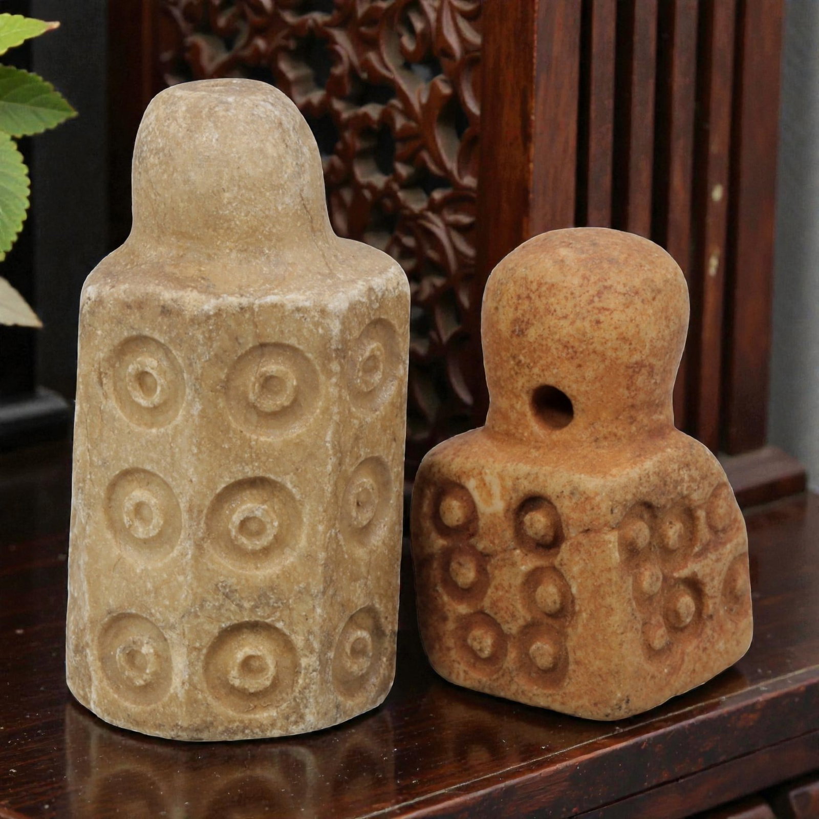Lot of 2 Ancient Mesopotamian Stone Stamps Seals, 80WM: A collection of two ancient Mesopotamian stone stamps, carved from light-colored stone. The taller example features a cylindrical, faceted body with repeated incised circle motifs, while the shorter p