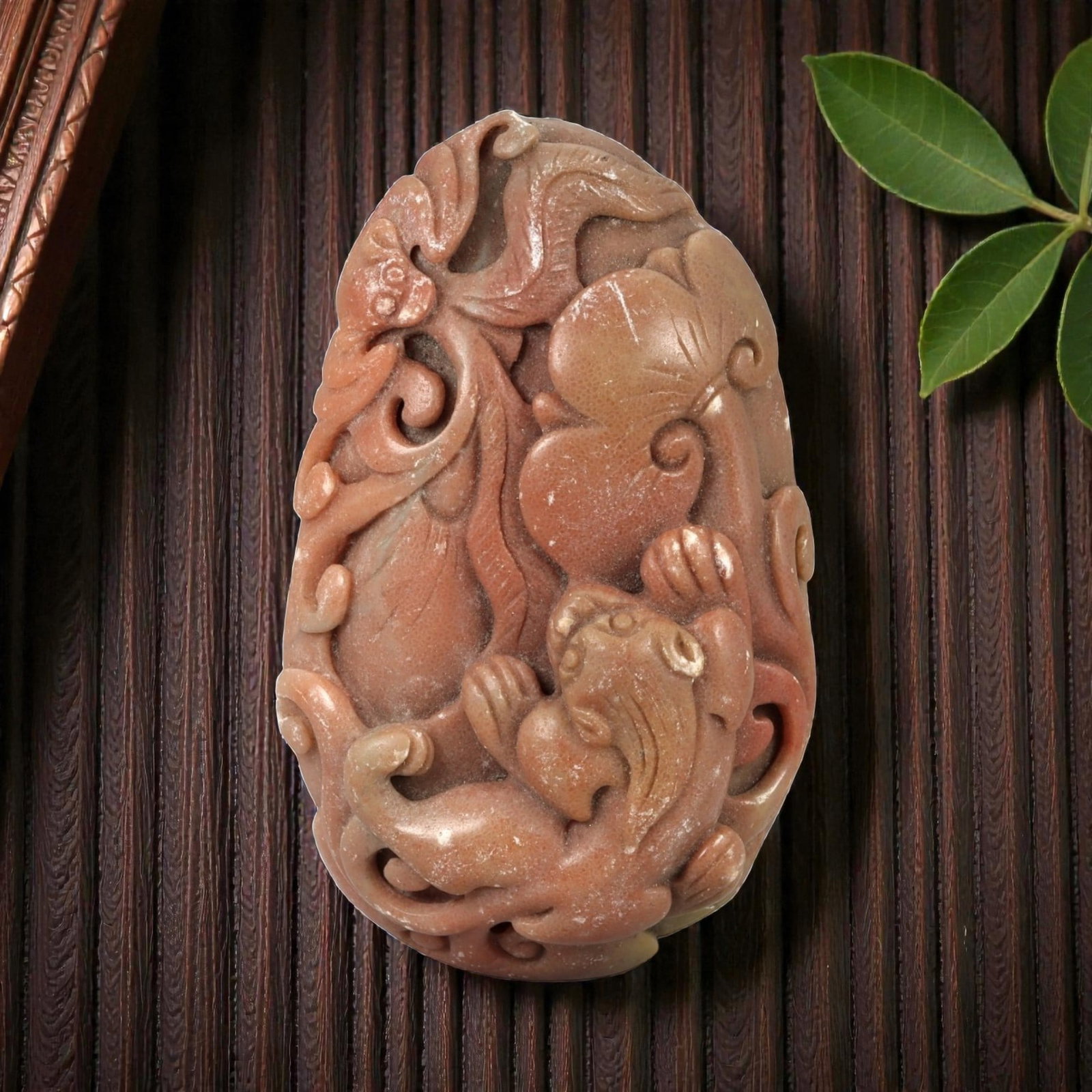 A Chinese Hardstone Carving with a Mythical Beast Pendant, 96FC: Carved from reddish-brown hardstone with subtle tonal variation and a matte to softly polished surface, the object is worked as a vertical plaque with rounded edges. The composition is executed in hig