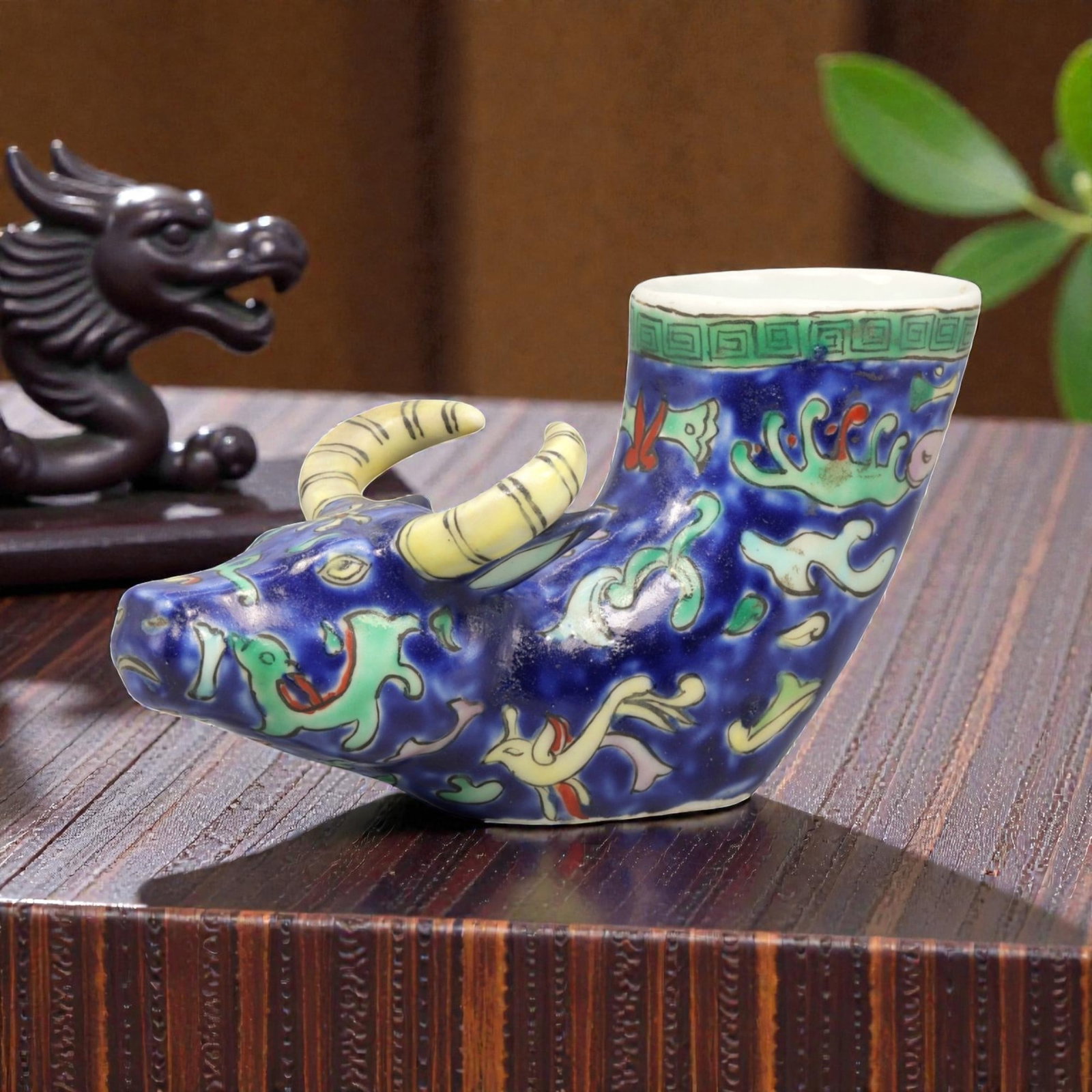 A Chinese Porcelain Bovine-Form Vessel, 20th Century, 87YC: Modeled in porcelain, the vessel is formed as a recumbent bovine with the head turned slightly to one side and the body hollowed to create an open container rising from the back. The animal is depicte