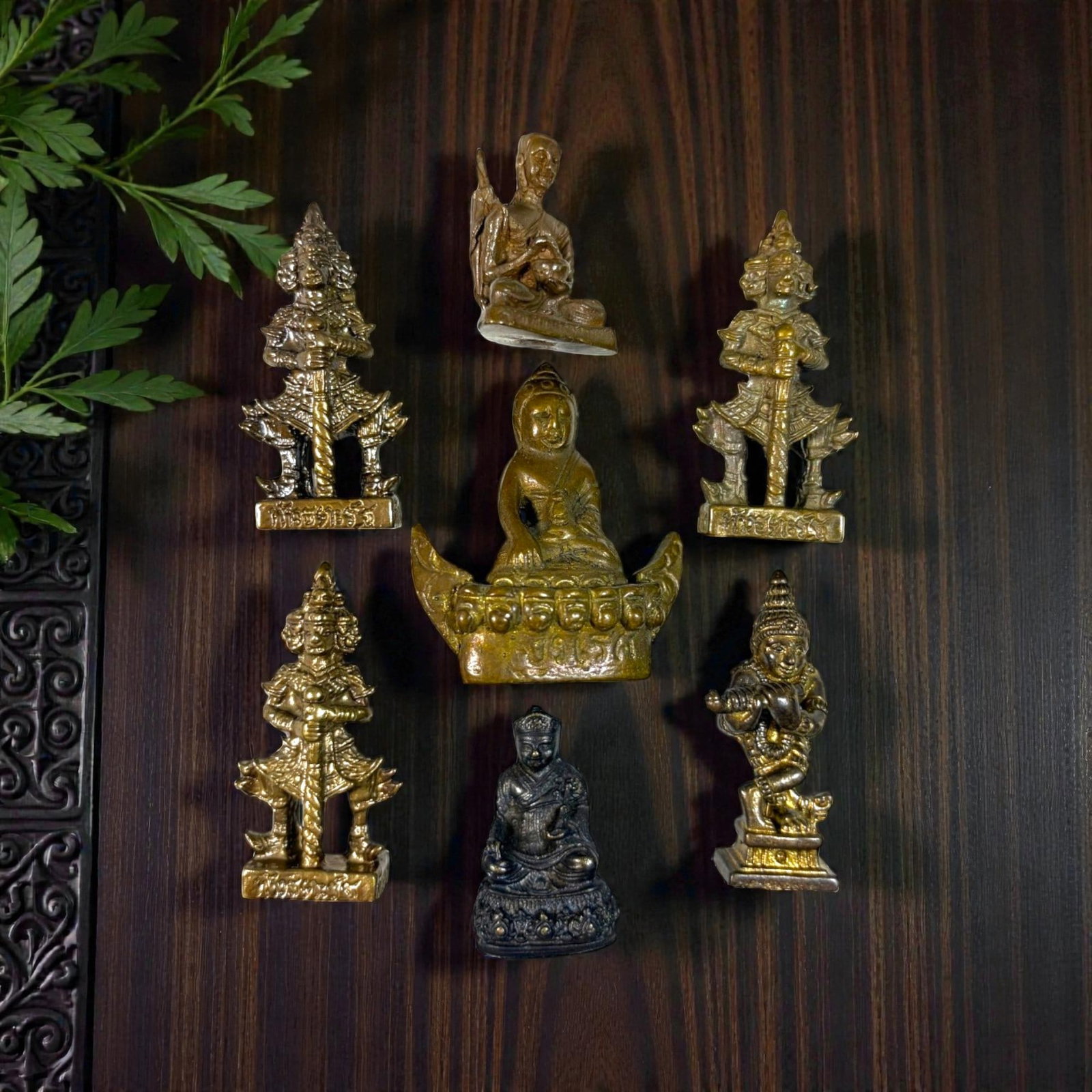 A Lot of 7 Vintage Southeast Asian Brass and Bronze Figurines, 50AA: Comprising seven small cast metal pieces ranging from 3 to 4.5 cm in height. The collection features a variety of devotional and guardian imagery, including seated Buddha and monk figures, multi-heade