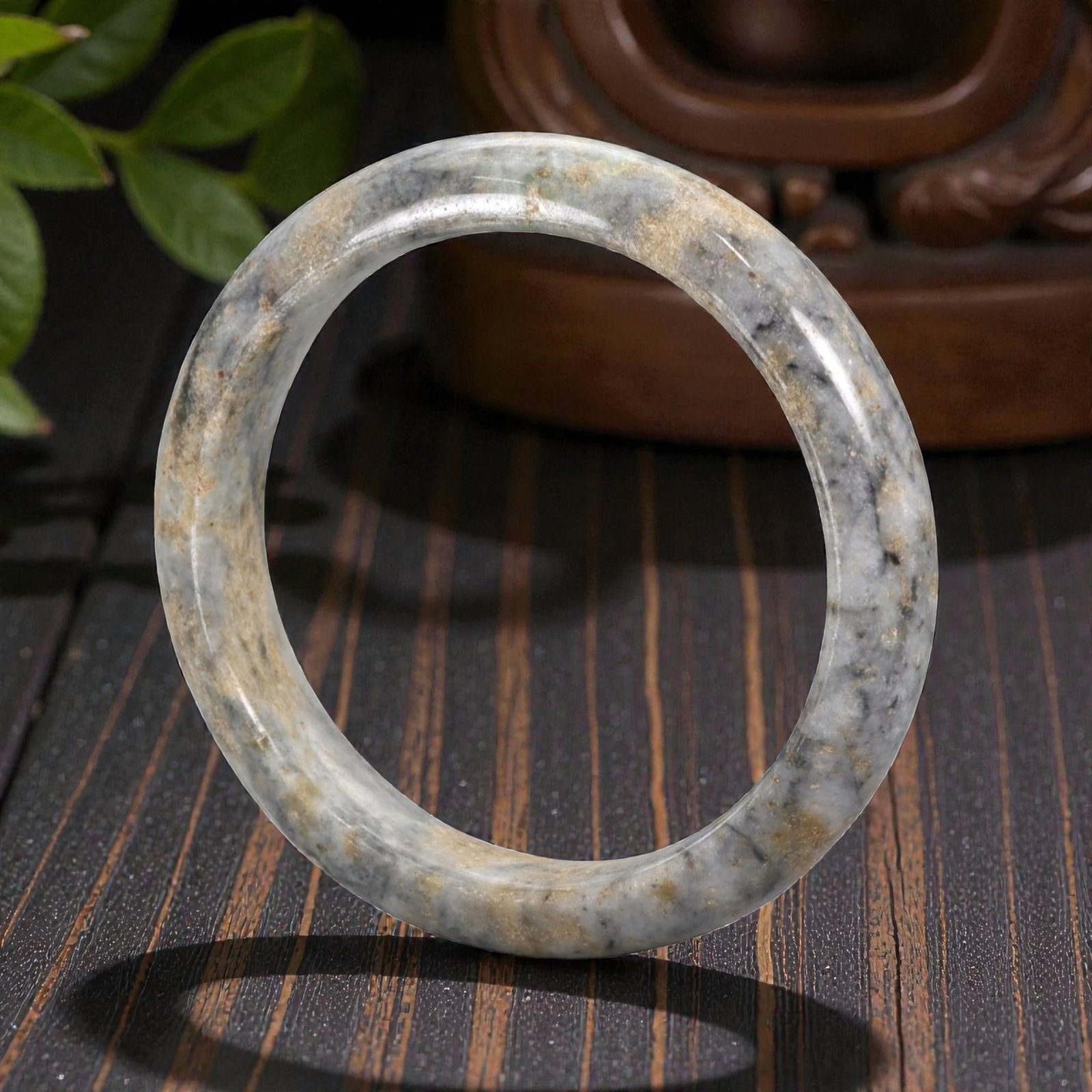Natural Burmese Type A Jadeite Jade Bangle Bracelet, 20th Century, 93ZK: Carved from jadeite jade with a pale greyish-white base and irregular tan and dark grey mottling, the bangle is formed as a continuous circular band with a rounded cross-section. The surface is smooth