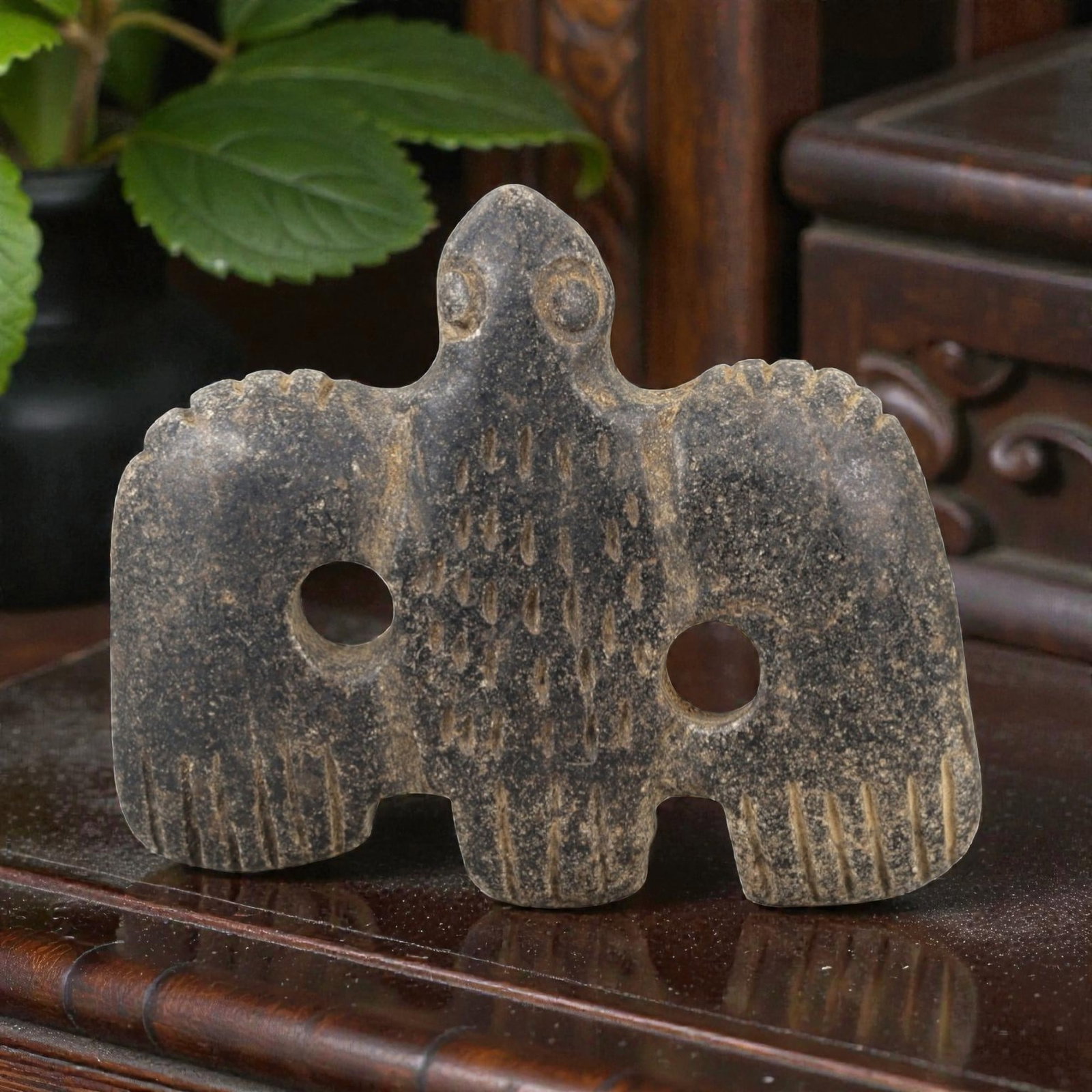 Ancient Stone Vulture Amulet - Near Eastern Bird Figure, 27AM: This vulture amulet is carved from dark speckled stone, depicting a stylized bird of prey (vulture) with outstretched wings and a compact body. The piece features incised linear and stippled detailing