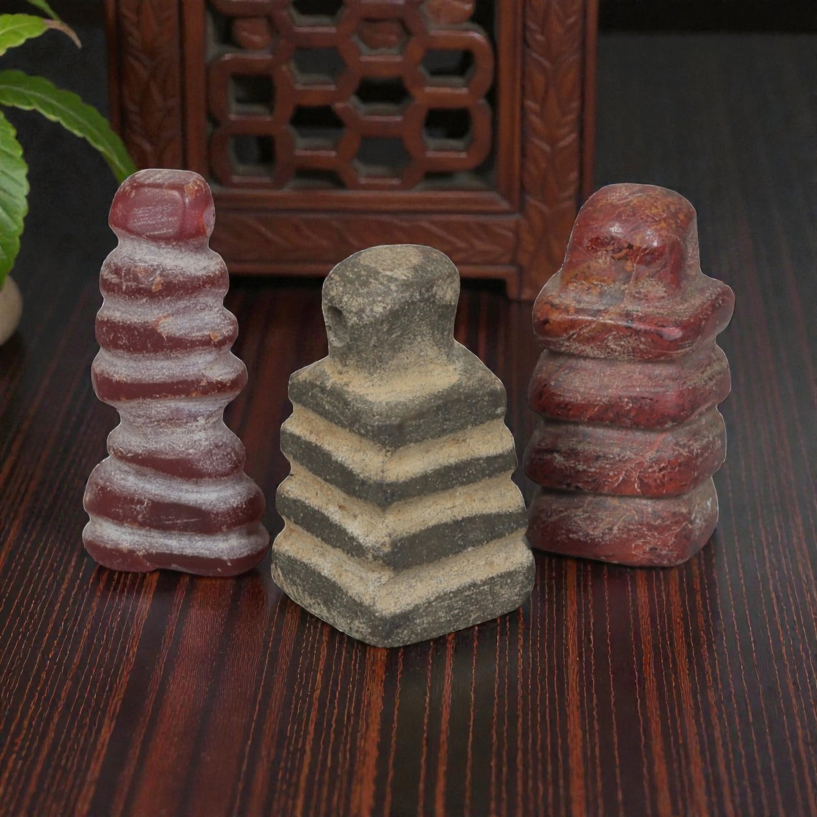 Lot of 3 Ancient Egyptian Stone Amulets, Late Period to Ptolemaic Period, 45AE: Comprising three tiered stone amulets of varying colour and form. Two examples are carved from red stone with stepped spiral and rectangular tiered forms, exhibiting surface patination and wear. The c