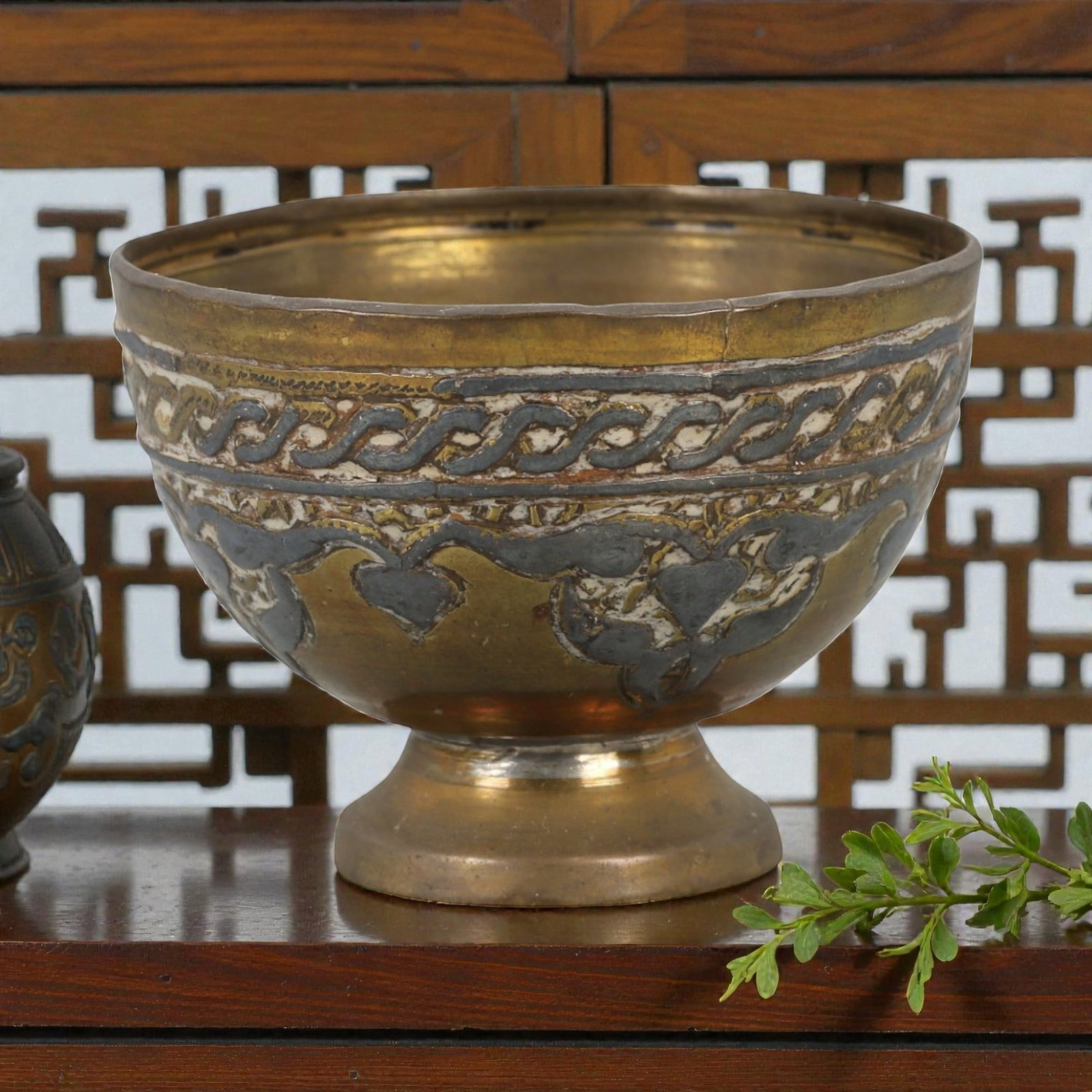 An Antique Islamic Niello Inlay Gilt Brass with Silver Footed Bowl, 53AG: Crafted from brass with silver and niello inlay, the footed bowl features a rounded body rising to a slightly flared rim, supported by a short, cylindrical foot. The exterior is decorated with two hor