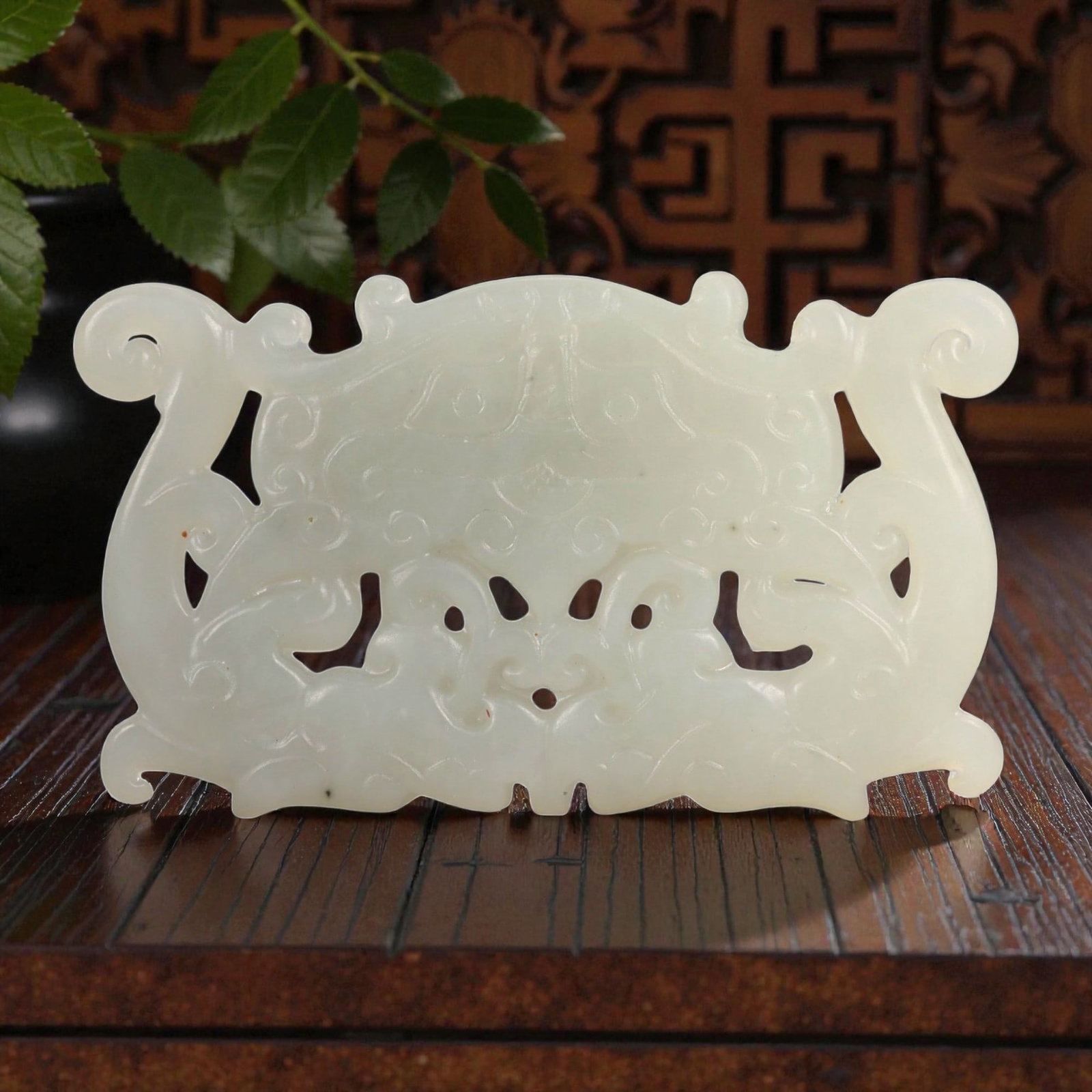 A Chinese Hetian Nephrite Jade Openwork Plaque, 67FD: Carved from pale celadon Hetian nephrite jade with even translucency and minor natural inclusions. The plaque is horizontally oriented and worked in openwork and low relief, with a symmetrical composi