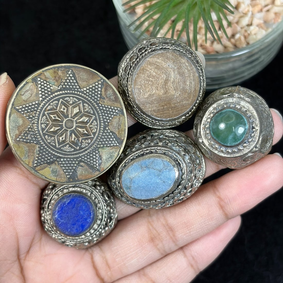 Vintage Tibetan Carved Silvered Mixed Stone Inlay Rings Lot, 11AS: This grouping holds five untested silvered and partial gilt adjustable rings crafted in traditional Himalayan Tibetan tribal design, featuring elaborate hand-carved granulation, scrollwork, and star f