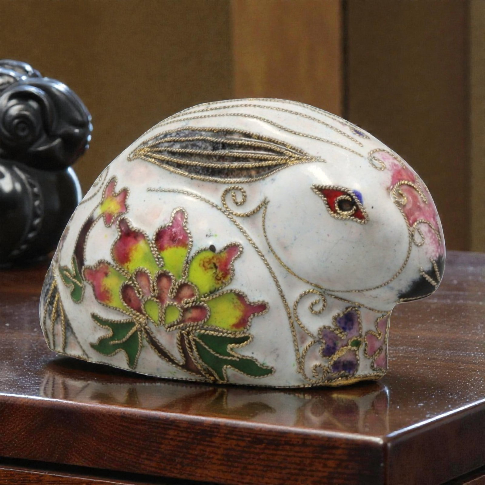 A Chinese Cloisonne Enamel Rabbit Effigy, 20th Century, 67YC: Constructed from a copper alloy body and decorated with cloisonne enamel, the object is formed as a recumbent rabbit with the head raised and the body tucked beneath. Fine metal wire cloisons delineat