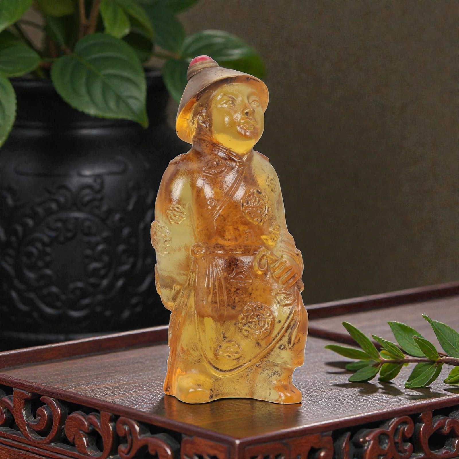 A Chinese Molded Glass Figural Snuff Bottle, 20th Century, 72FG: The snuff bottle is molded in the form of a standing male figure, likely representing a traditional attendant or official, dressed in long robes and a brimmed hat. The glass is of warm amber-golden to
