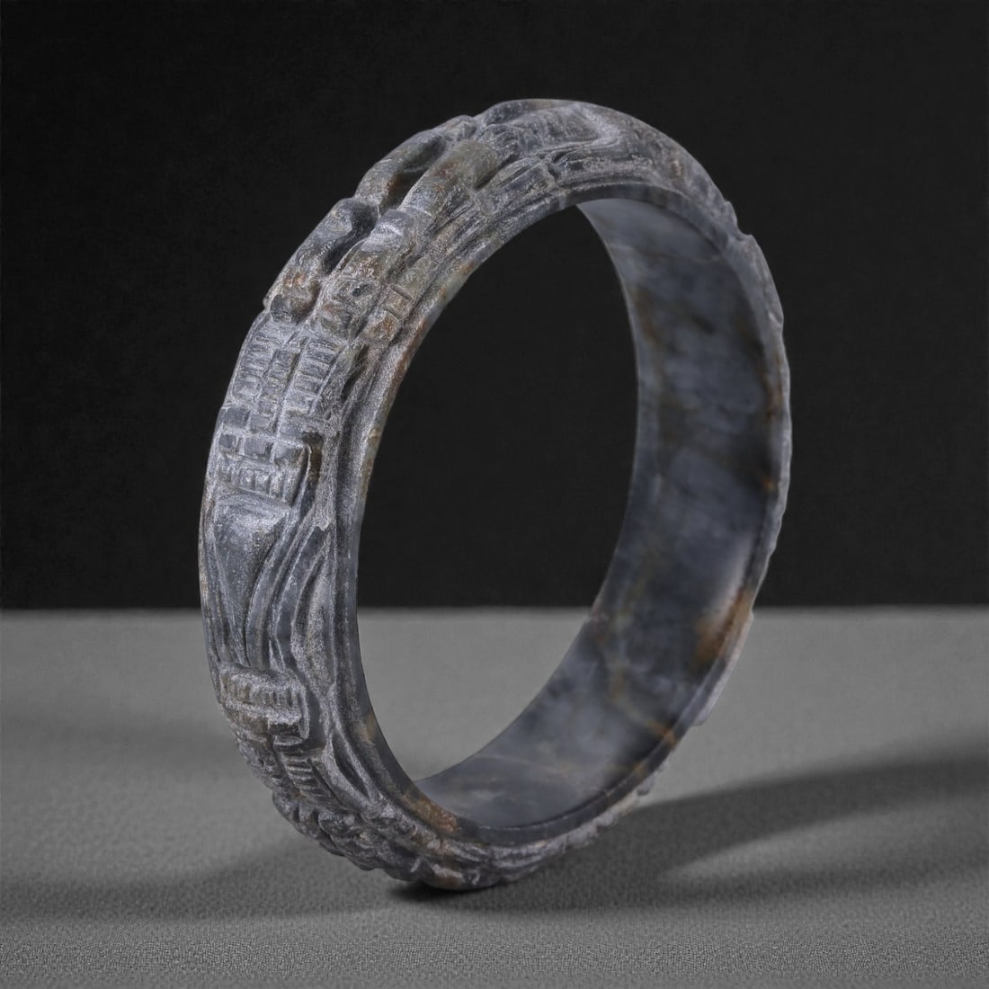Natural Burmese Type A Jadeite Jade Dragon Bracelet, 6.3cm Inner Diameter, 21WE: Carved from dense grey-green jadeite, this bracelet is formed as a continuous circular bangle with sculptural relief carving along the exterior surface. The stone has been hollowed and shaped through 