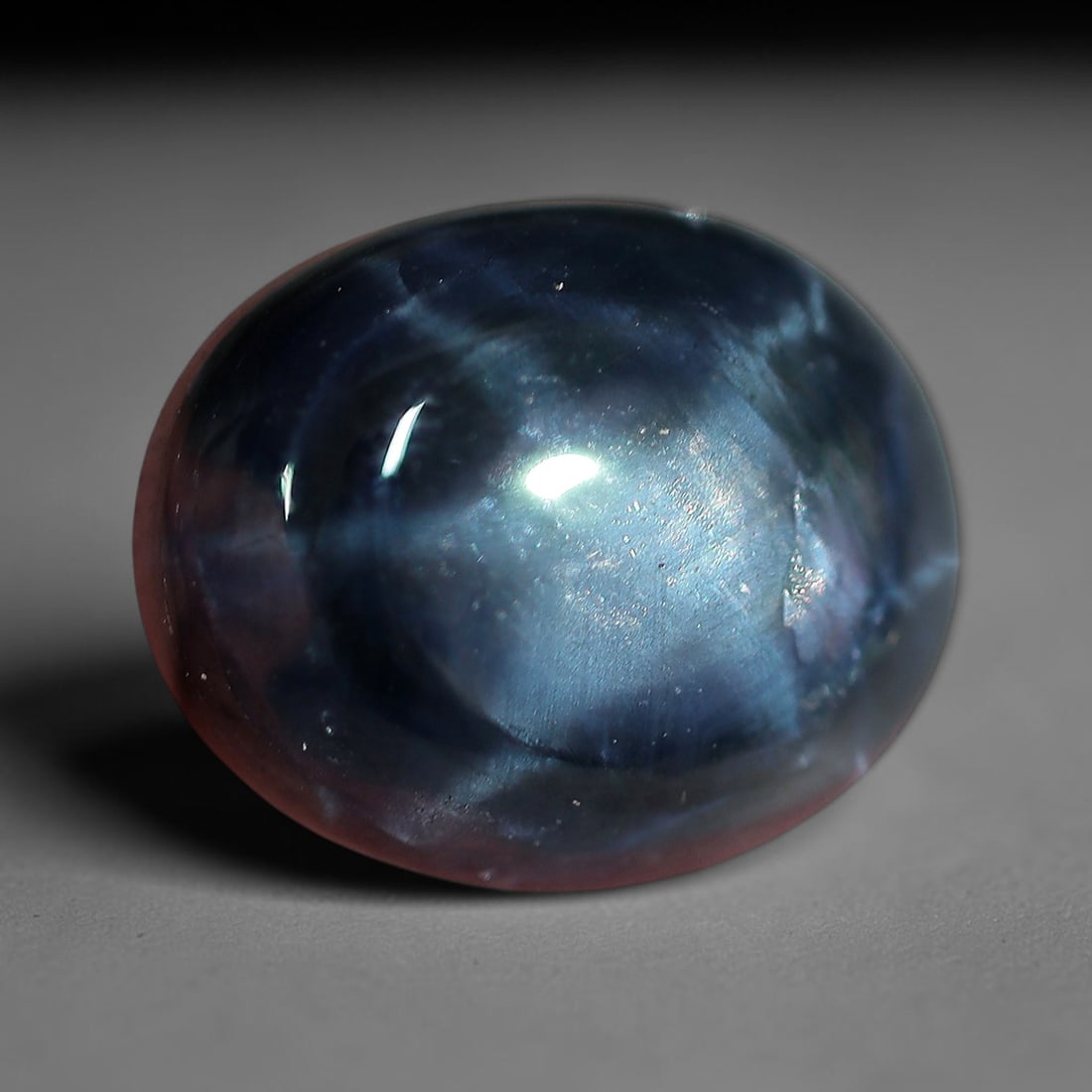 6.17 Carats Twilight Blue Star Sapphire Oval Cabochon - Natural Loose Gemstone, 35XC: This substantial oval star sapphire captures the moody beauty of twilight skies, with a rich, shifting blue hue that deepens from soft misty tones at the center to velvety indigo at the edges. A lumin