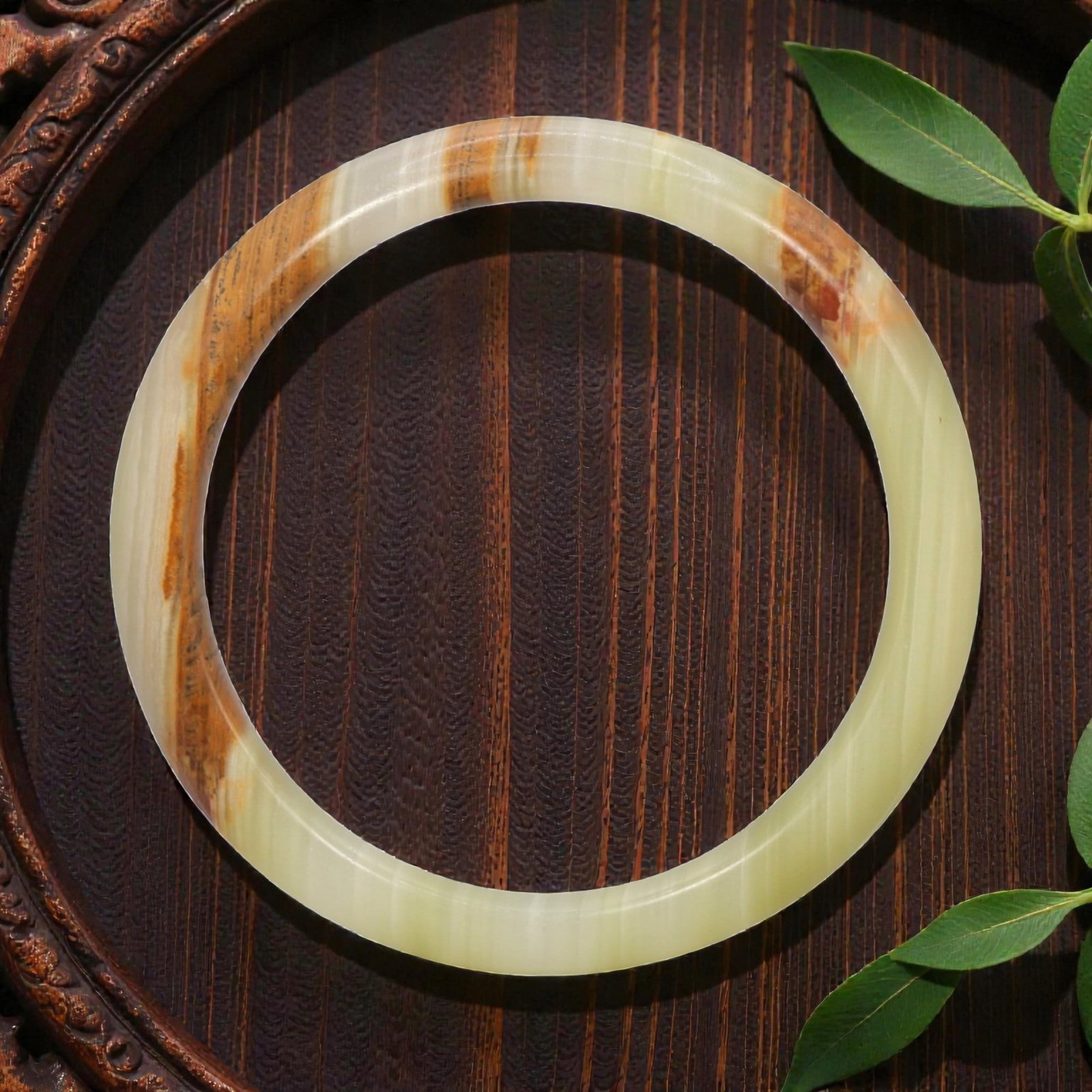 A Chinese Hetian Jade Bangle Bracelet, 20th Century, 21YC: Carved from a single piece of Hetian nephrite jade, the bangle is formed as a continuous circular hoop with a rounded exterior profile and a flat inner edge, smoothly polished to a soft surface luster