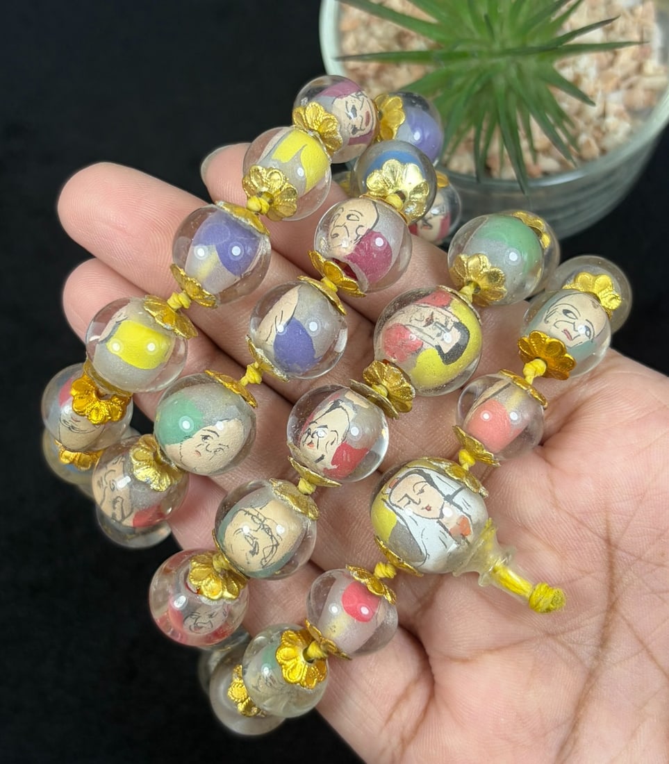 A Chinese Glass Beaded Necklace with Inner Drawing, 38FJ: The necklace is composed of a long strand of spherical transparent glass beads, each finely decorated with inner-painted figural portraits rendered in black line against softly colored grounds of red,