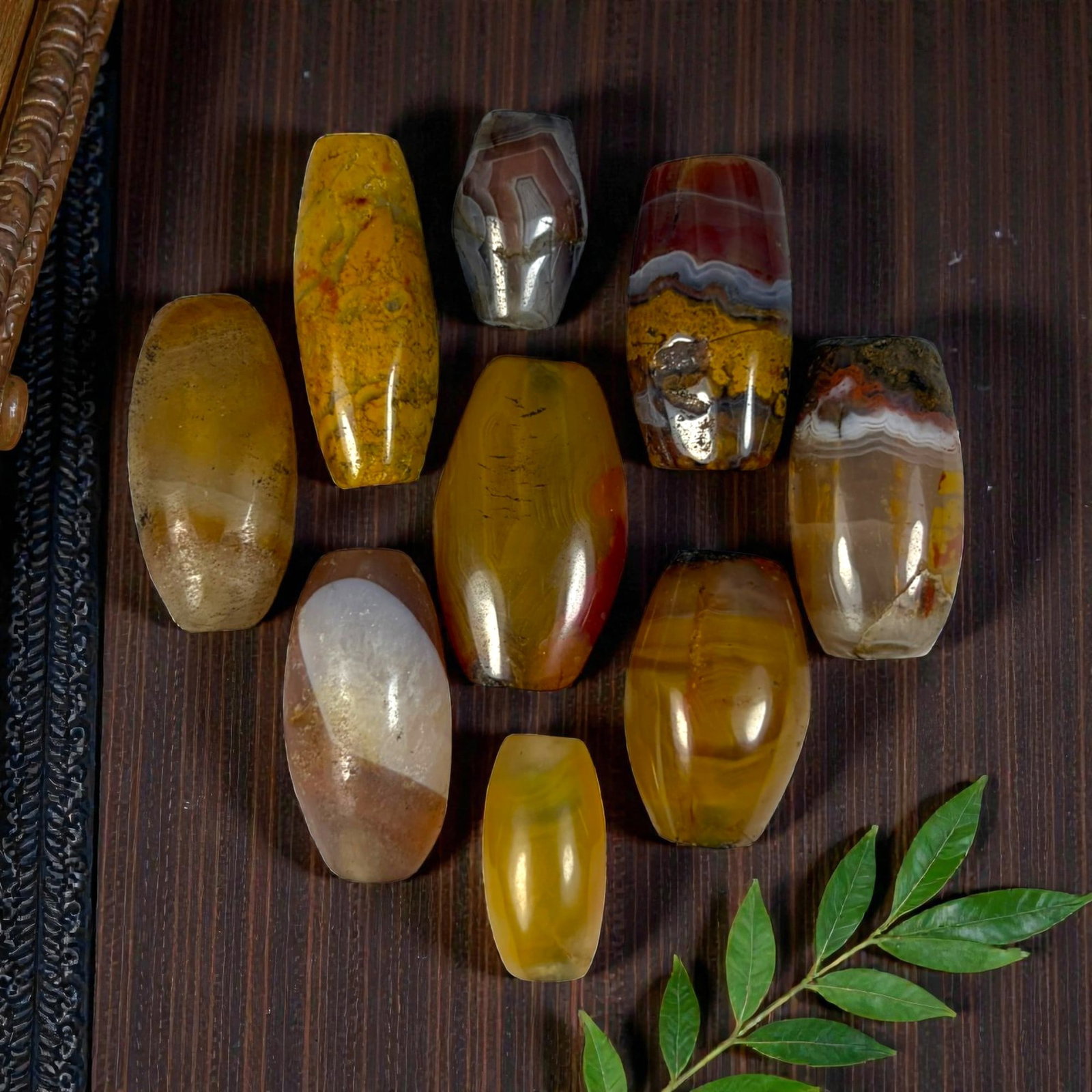 A Lot of 9 Himalayan Banded Agate Beads, Ancient to Antique Period, 27YD: Comprising lot of barrel and ovoid beads, each carved from banded agate with natural tonal variations, many displaying characteristic concentric, linear, and dendritic patterns. The surfaces exhibit s