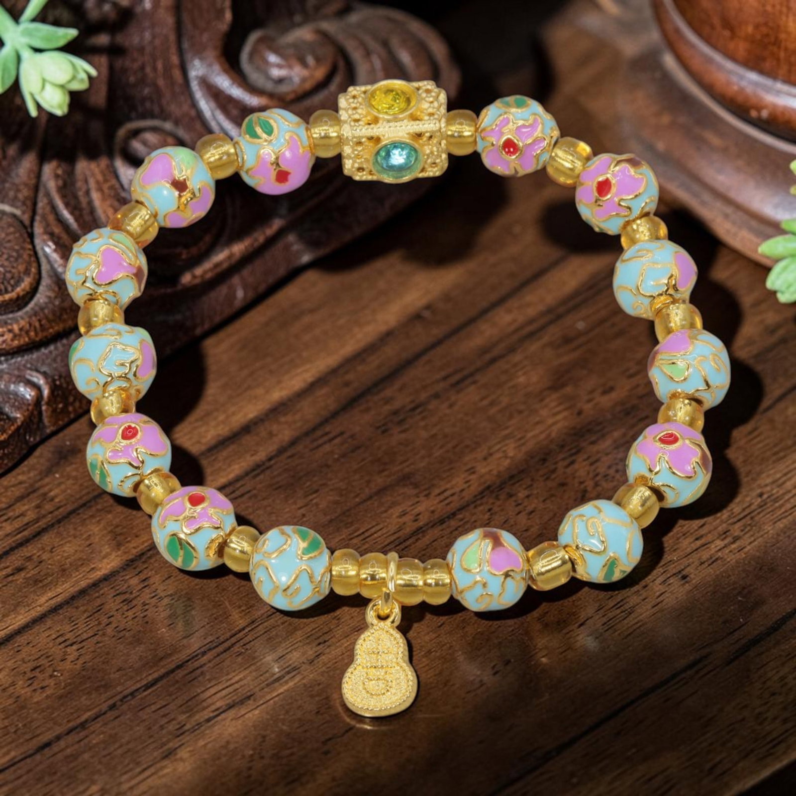 A Chinese Cloisonne Enamel Beaded Bracelet - Gold-Tone Gourd Charm, 34YJ: This modern Chinese-style bracelet is crafted with 9.65mm round cloisonne enamel beads, alternating between light blue and pastel pink floral motifs outlined in polished gold-tone metal. A central squ