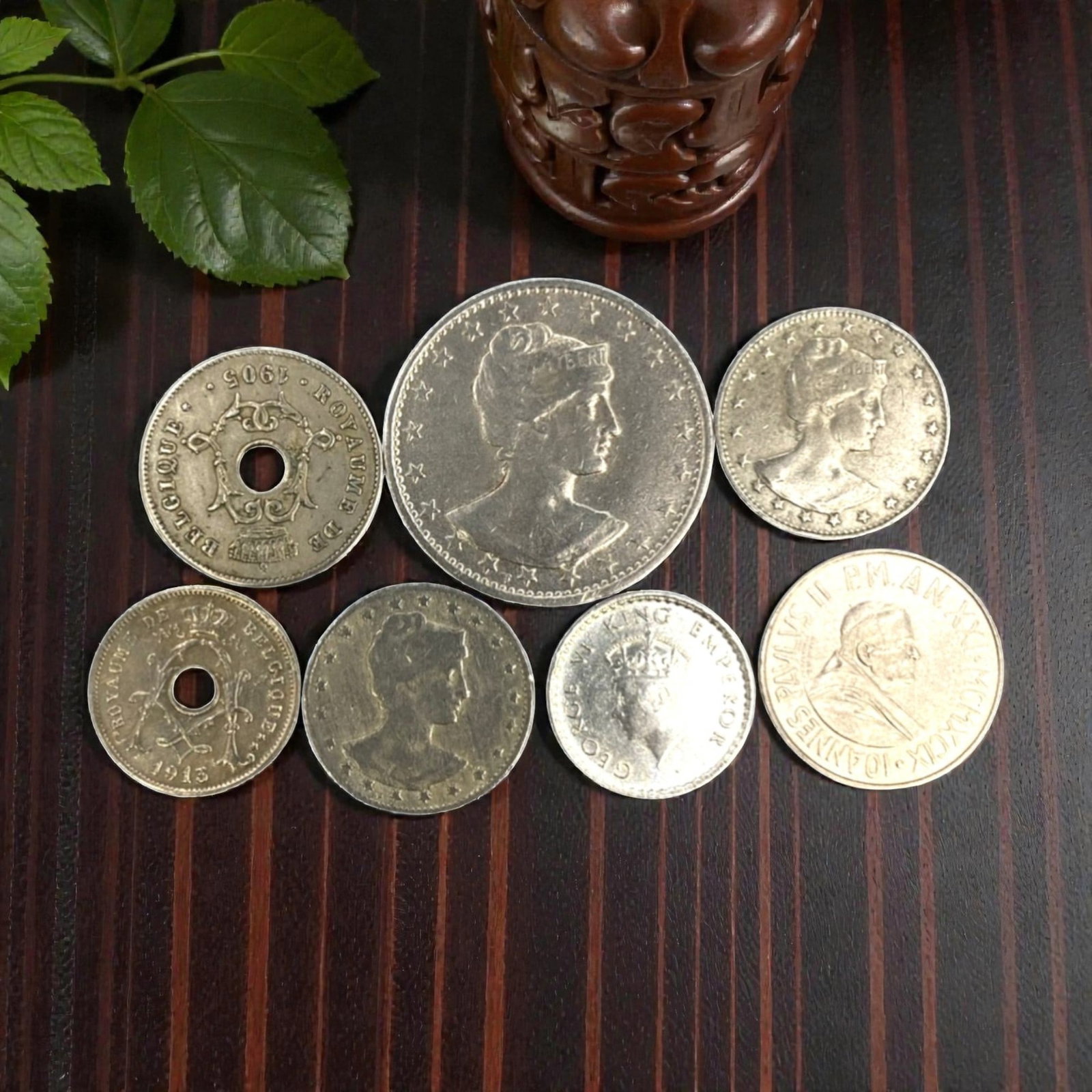 GLOBAL: Sovereignty & Faith - 7-Piece Coins Set, 1943-1969, 19-30mm, 20ZJ: This curated 7-Piece Coins Set spans the mid-20th century, featuring coins from Belgium, Brazil, Vatican City, and British colonial issues, ranging from 19 to 30mm in diameter. Each piece anchors to a