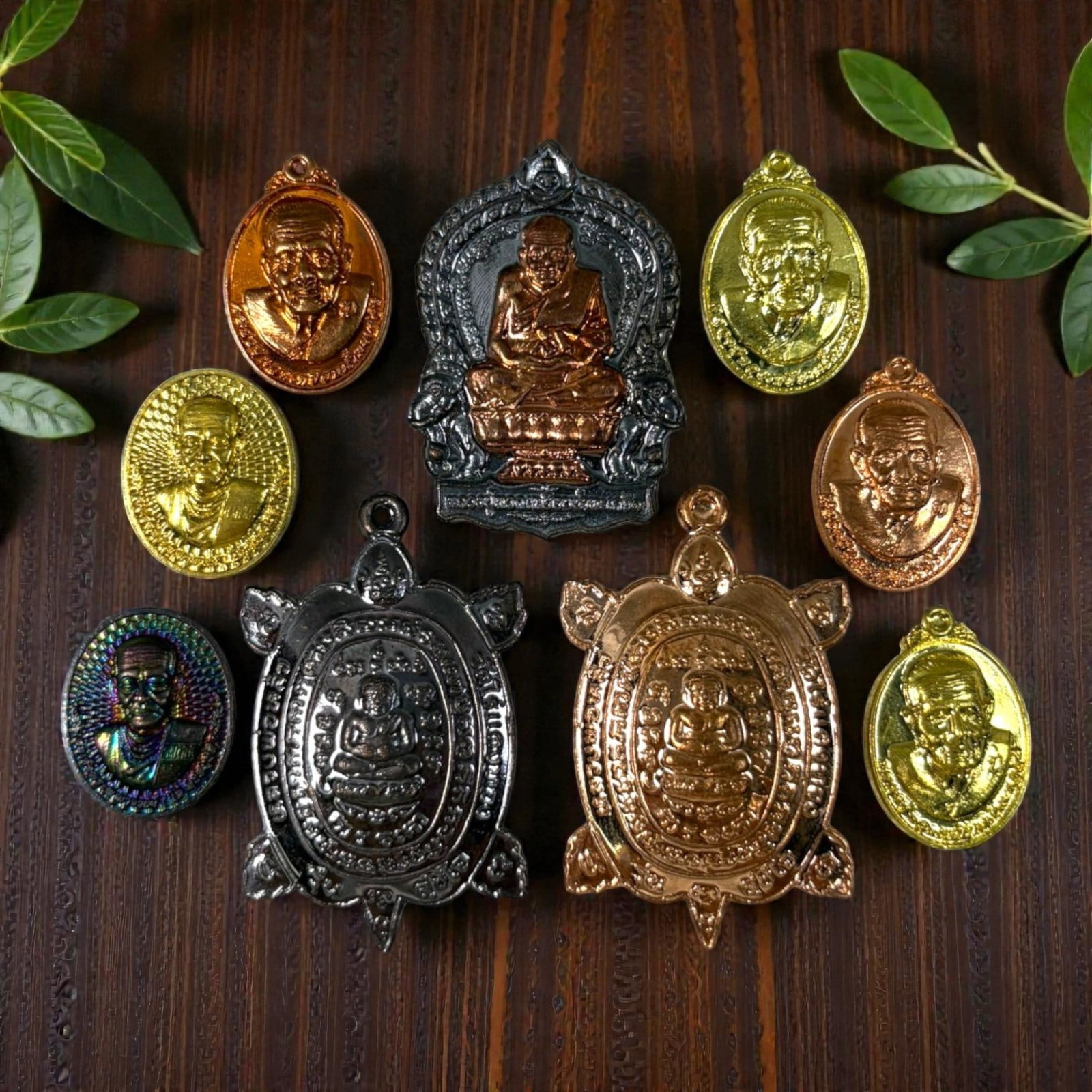 A Lot of 9 Vintage Thai Buddhist Amulets, Monk Medallions and Turtle Charms, 44AA: Comprising nine small pendants ranging from 2 to 4 cm in height. The collection features seven oval monastic portrait medallions in various metal finishes (gold, copper, blackened, and iridescent-tone