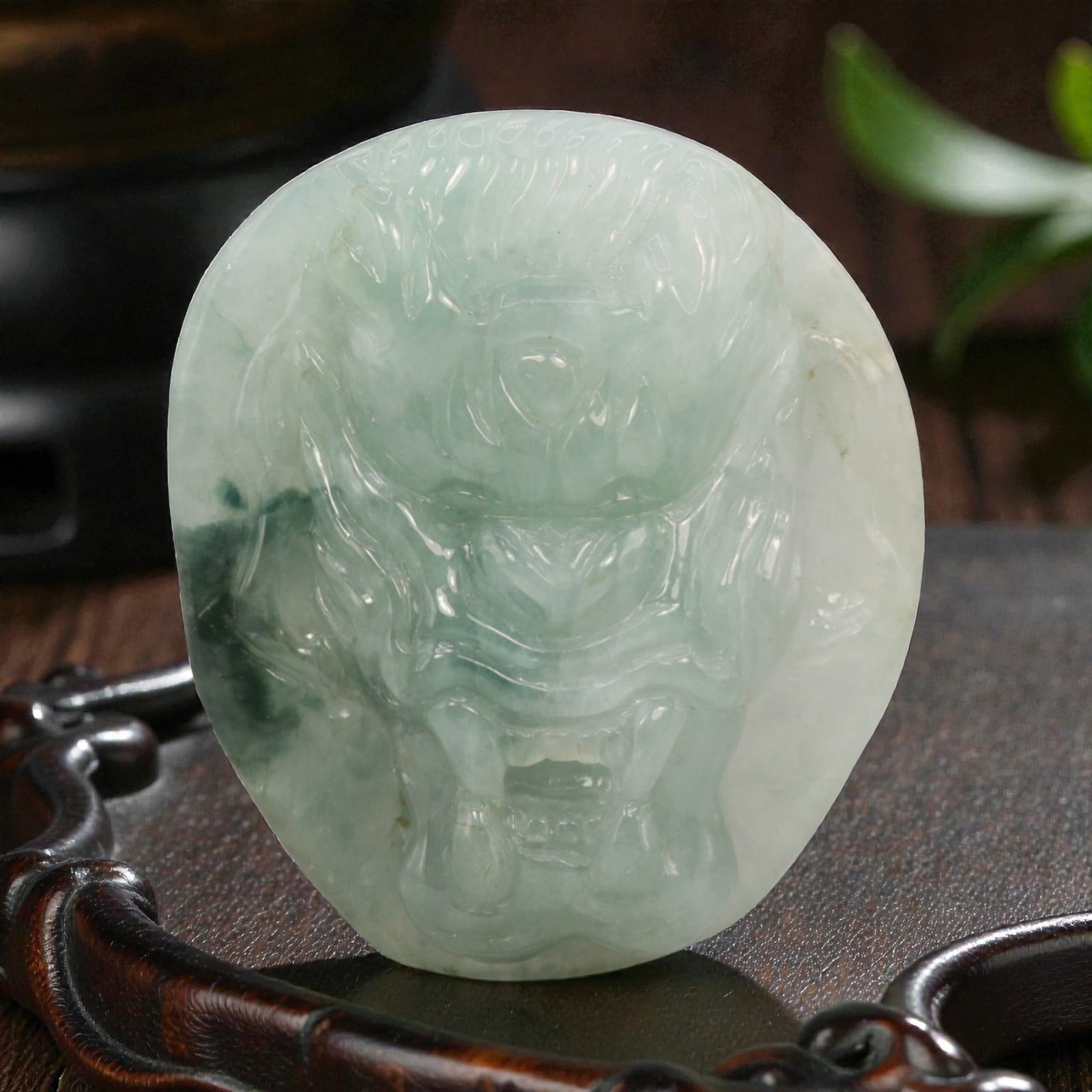 Natural Burmese Type A Jadeite Jade Dragon Head Pendant, 20th Century, 15ZL: Carved from pale celadon jadeite with natural dark green dendritic inclusions concentrated on the left side, the object is shaped as a flattened, irregular oval. The front is rendered in mid-relief wi