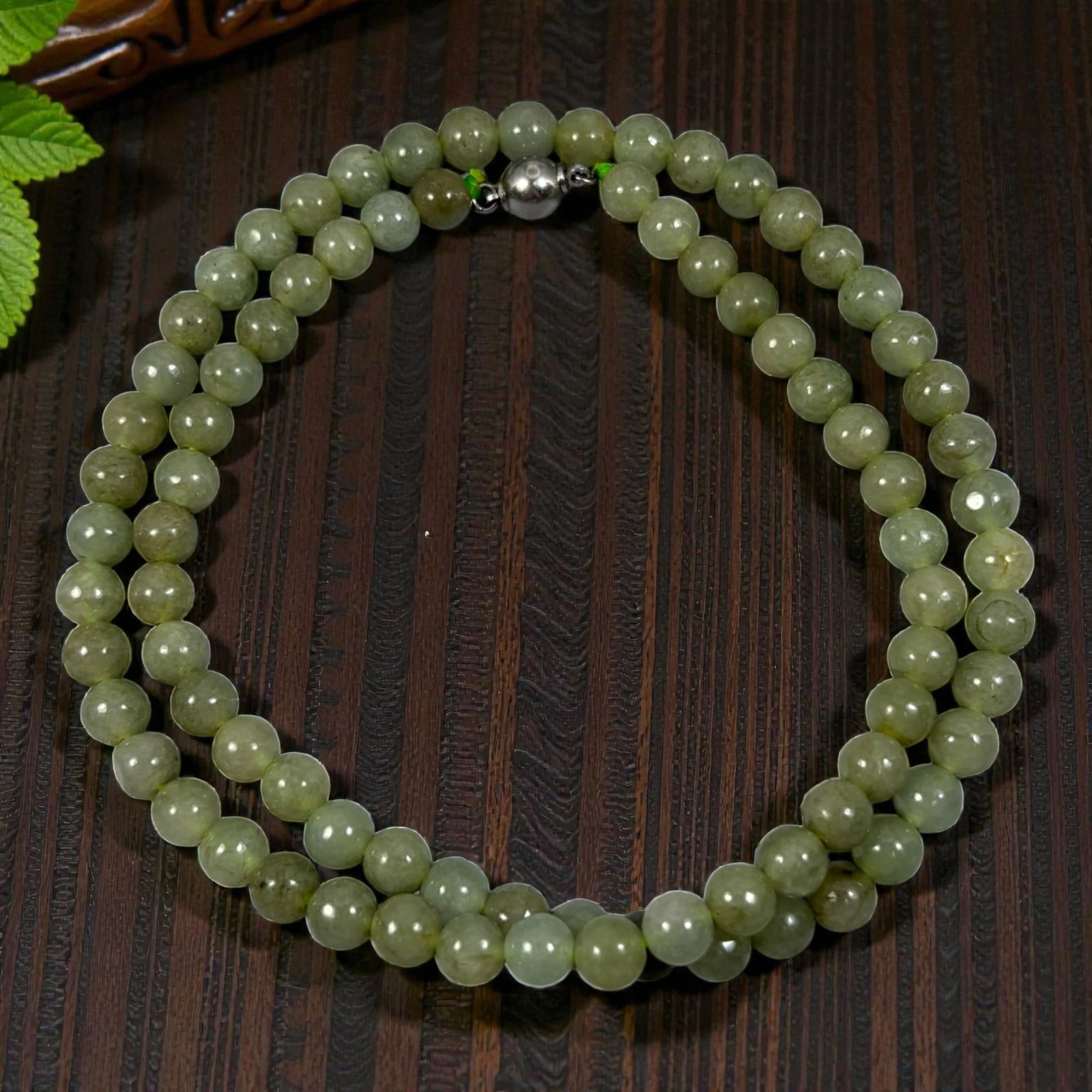 Natural Burmese Olive Green Type A Jadeite Jade Bead Necklace, 32YG: A continuous strand of evenly spherical polished Type A jadeite beads displaying a consistent muted olive green tone, with inherent natural mineral inclusions and subtle shade variations present throu