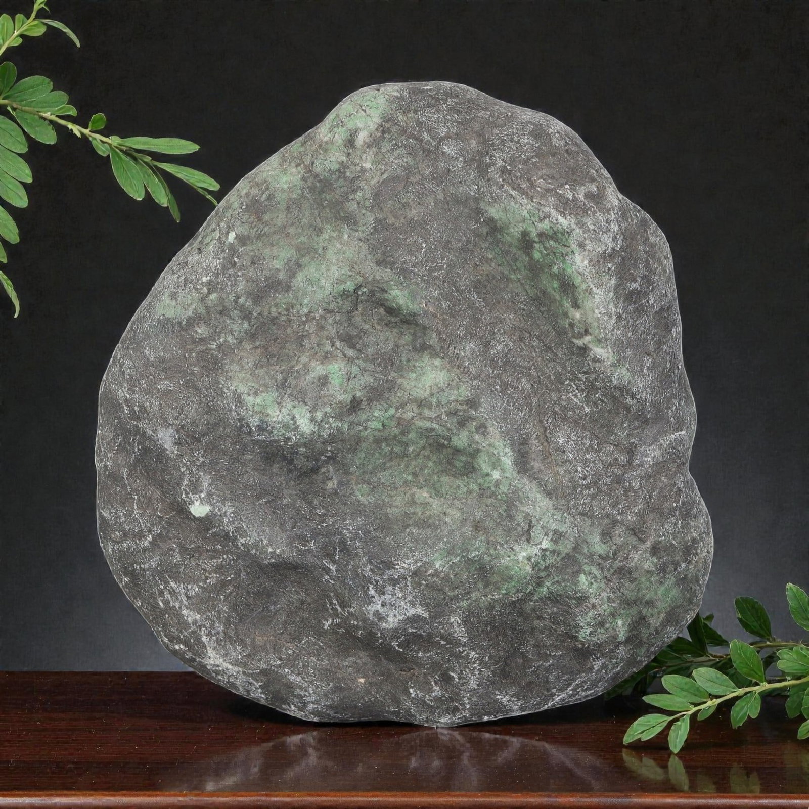 3010ct Natural Burmese Dark Skin Green Patches Jadeite Jade Rough Stone, 87EA: This is a natural Type A Burmese jadeite jade rough stone, measuring 9x8.5cm and weighing 602g (3010ct). It features a rugged dark grey mine skin with large patches of natural green jadeite peeking th