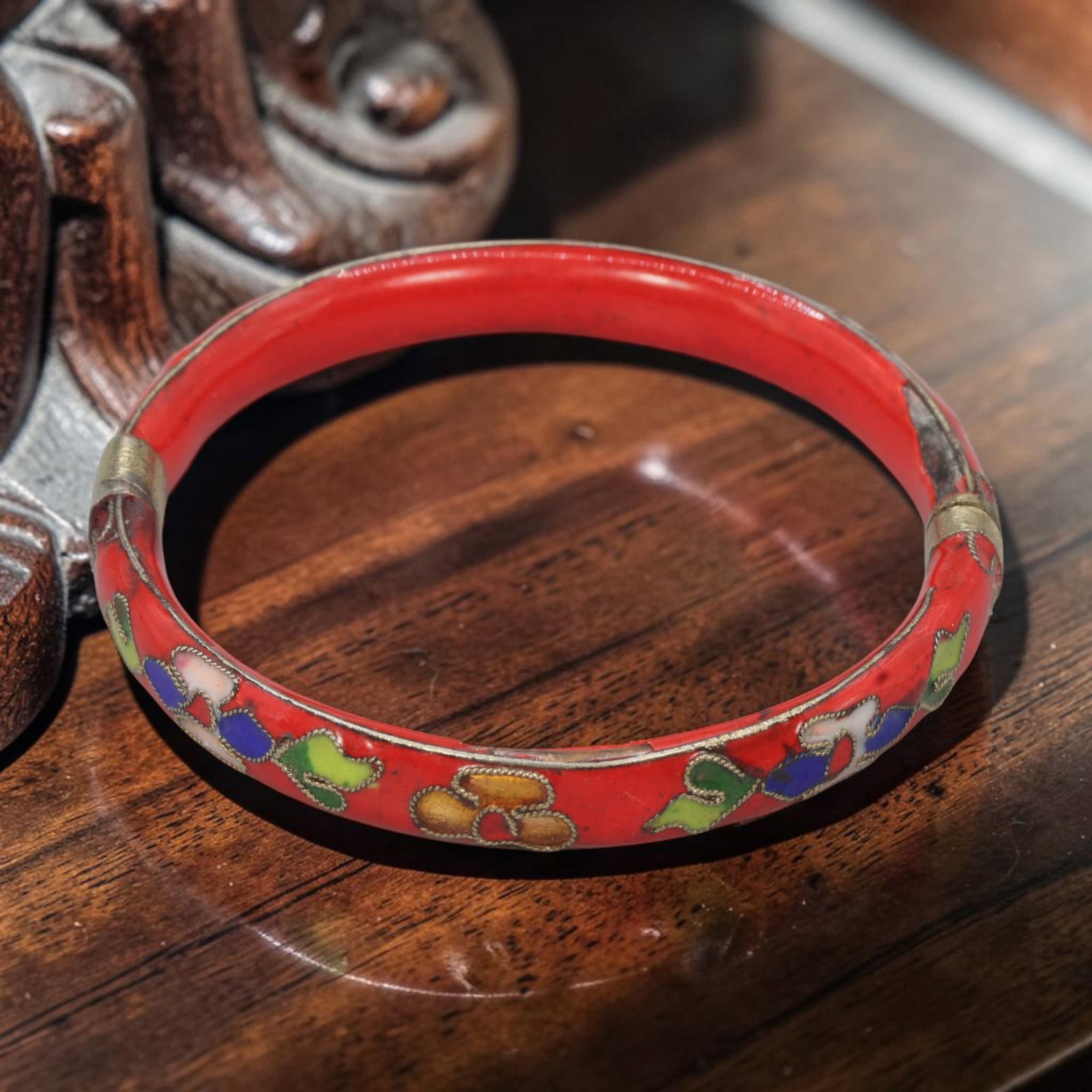 A Chinese Vintage Red Cloisonne Enamel Hinged Bangle Bracelet, 26YJ: This classic Chinese-style hinged bangle bracelet features a vibrant red enamel base, adorned with traditional multicolored floral cloisonne motifs in blue, green, pink, and gold, all outlined with fi