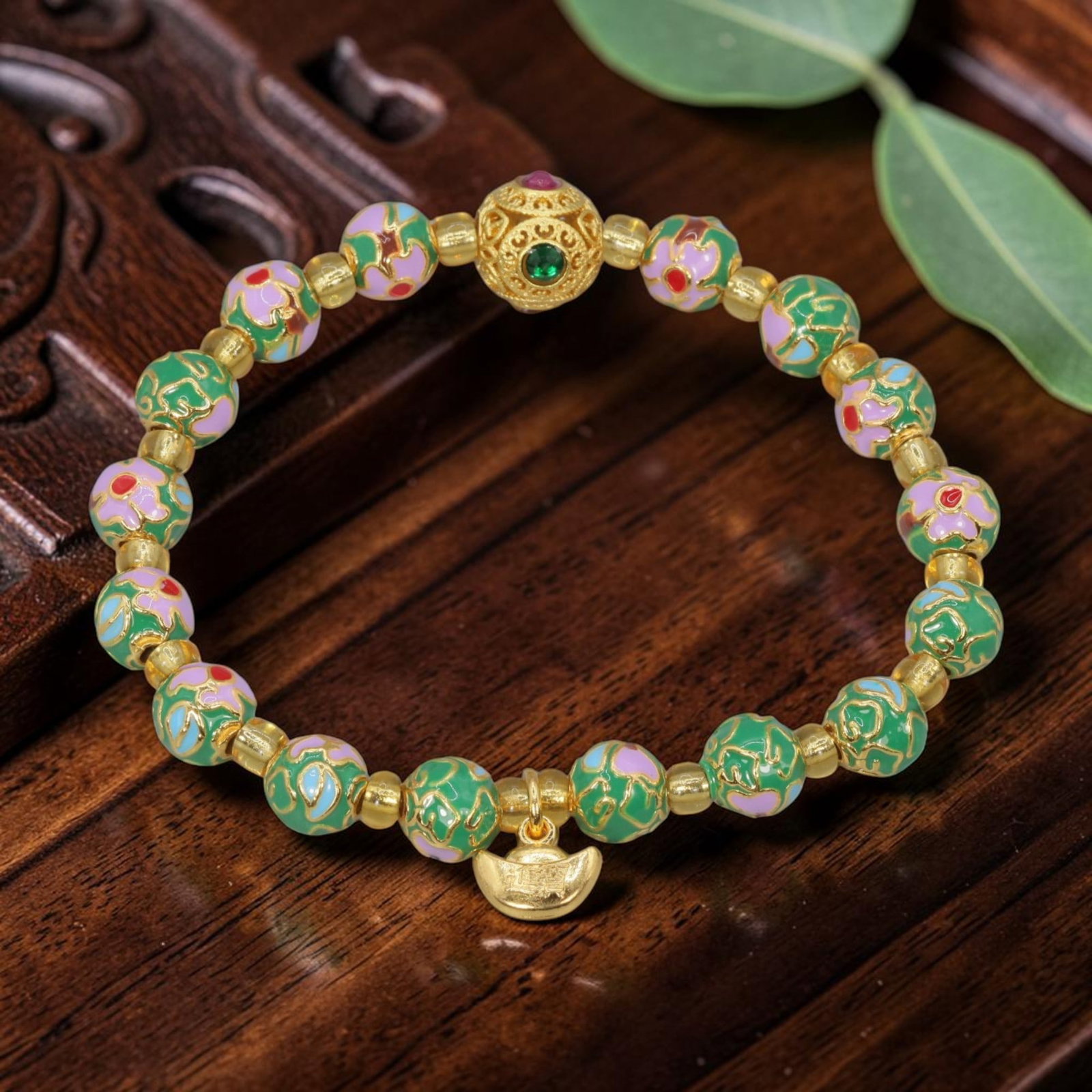 A Chinese Cloisonne Enamel Beaded Bracelet - Green Gold-Tone Ingot Charm, 38YJ: This modern Chinese-style bracelet features 11.26mm round cloisonne enamel beads in a vibrant green hue, alternating with beads in soft purple and pink, each detailed with raised gold-tone floral patt