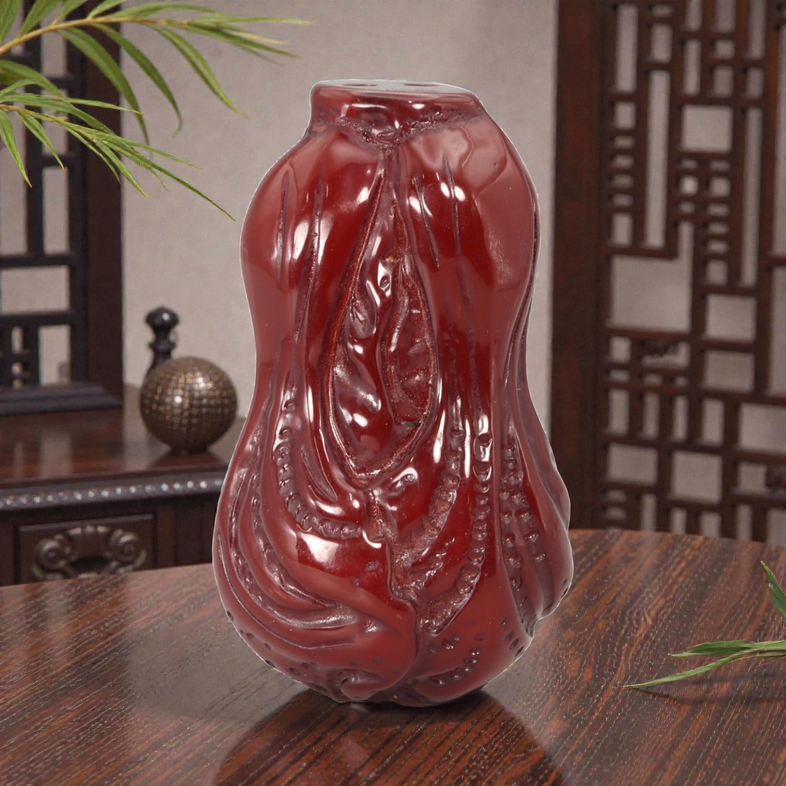 A Chinese Amber-Resin Cabbage Pendant, 20th Century, 38FC: Molded from translucent amber-colored resin with a deep red tone and high-gloss surface, the pendant is carved in the form of a cabbage with layered, curling leaves gathered into a compact, vertical c