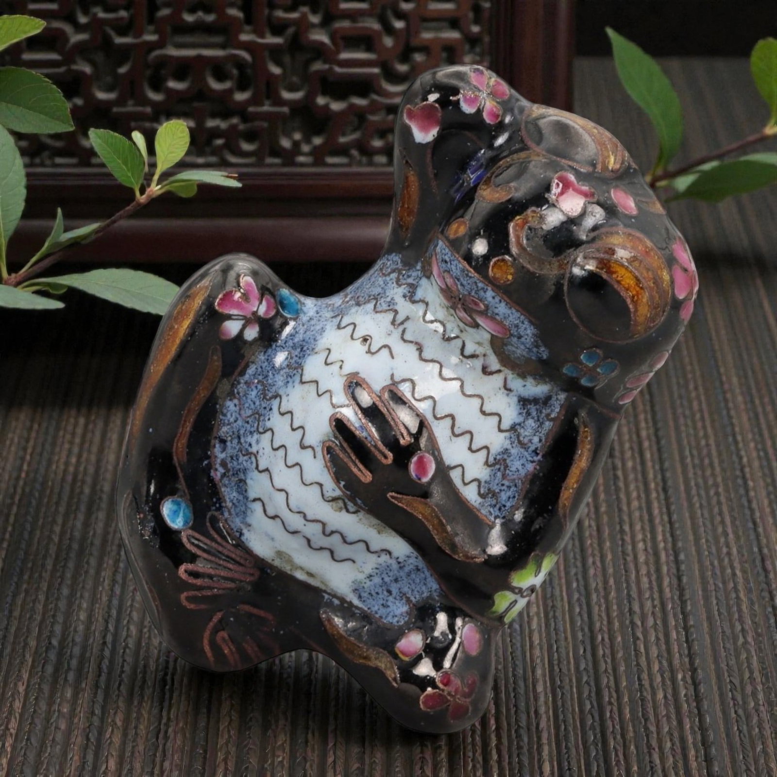 A Chinese Enamel Frog Effigy, 20th Century, 10FH: Modeled as a stylized frog shown seated upright with the head tilted upward and forelimbs drawn toward the chest, the effigy is formed from a metal core and decorated with painted enamel rather than c