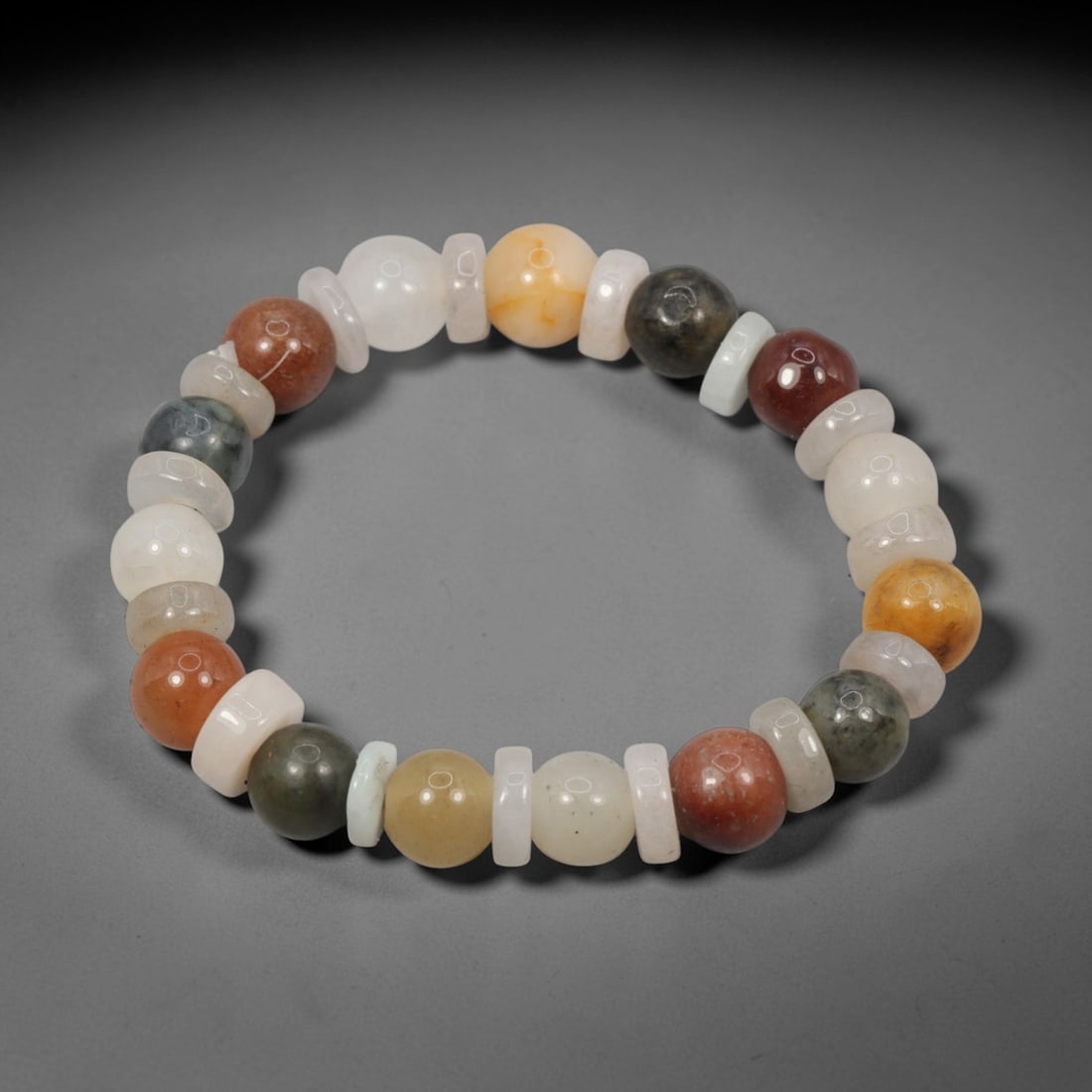 Natural Burmese Type A Jadeite Jade Mixed Shape Bead Bracelet, 46ZK: A hand-strung bracelet crafted from polished natural Burmese Type A jadeite, combining smooth rounded barrel beads paired with thin flat jadeite spacer discs. The beads feature a rich variegated palet