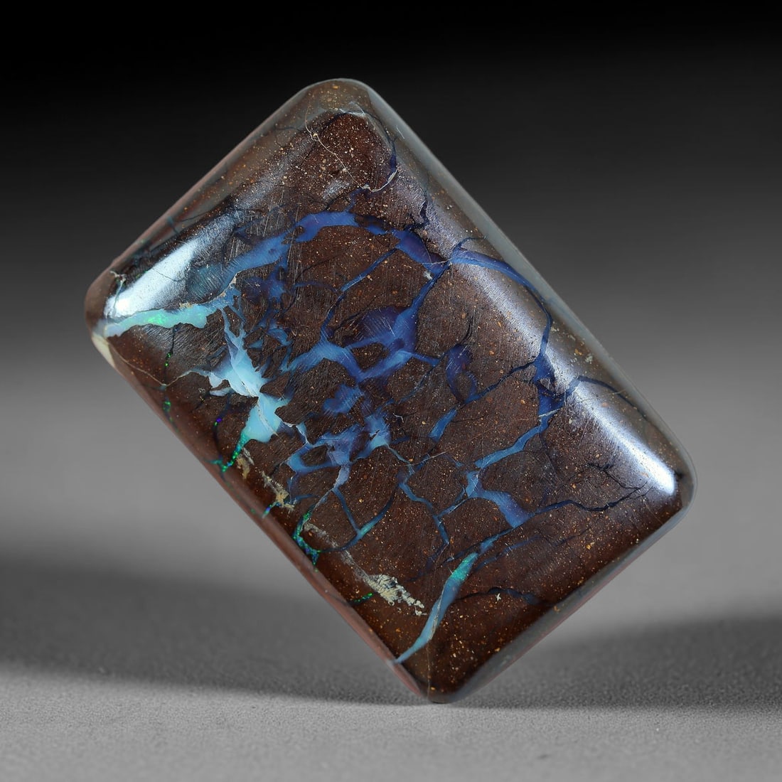 27.41ct Natural Australian Queensland Matrix Boulder Opal Cabochon, 10AV: Hand polished rounded rectangular cushion cabochon of natural Queensland matrix boulder opal, featuring speckled warm brown ironstone base matrix interlaced with intricate branching opal veins of deep