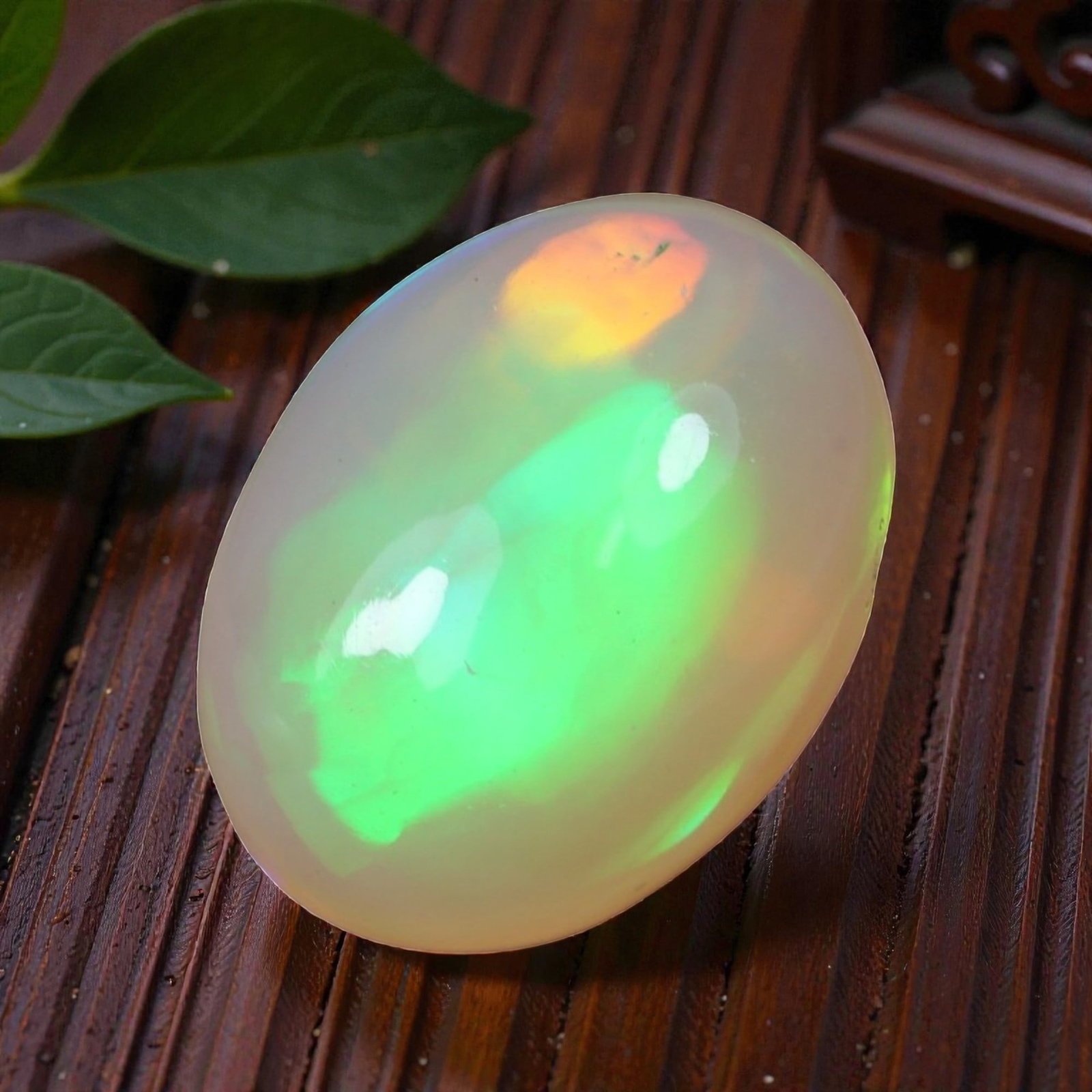 1.85 Carats Multicolor Flash Welo Opal Oval Cabochon - Natural Ethiopian Stone, 79XB: This exceptional Welo opal cabochon displays a breathtaking play of color, with vivid, sweeping flashes of electric green and warm sunset orange moving across its milky, translucent base. Measuring 10