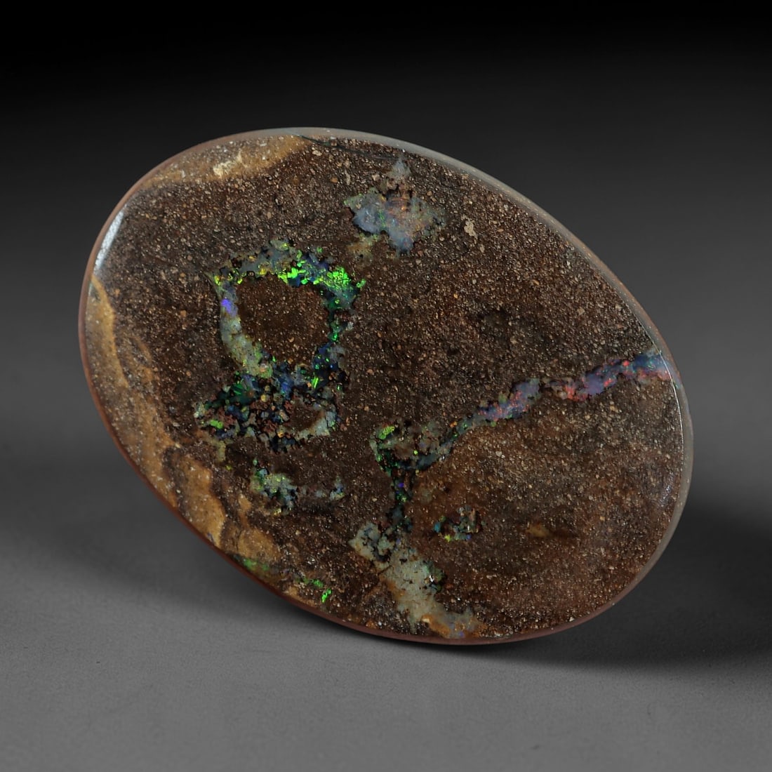 3.08 Carats Koroit Boulder Opal Cabochon - Natural Australian Stones 12.8x9.3mm, 2XM: This captivating 3.08-carat Koroit boulder opal cabochon is a natural work of geological art, featuring delicate, scattered veins of vivid green, blue, and iridescent play-of-color that glow against a