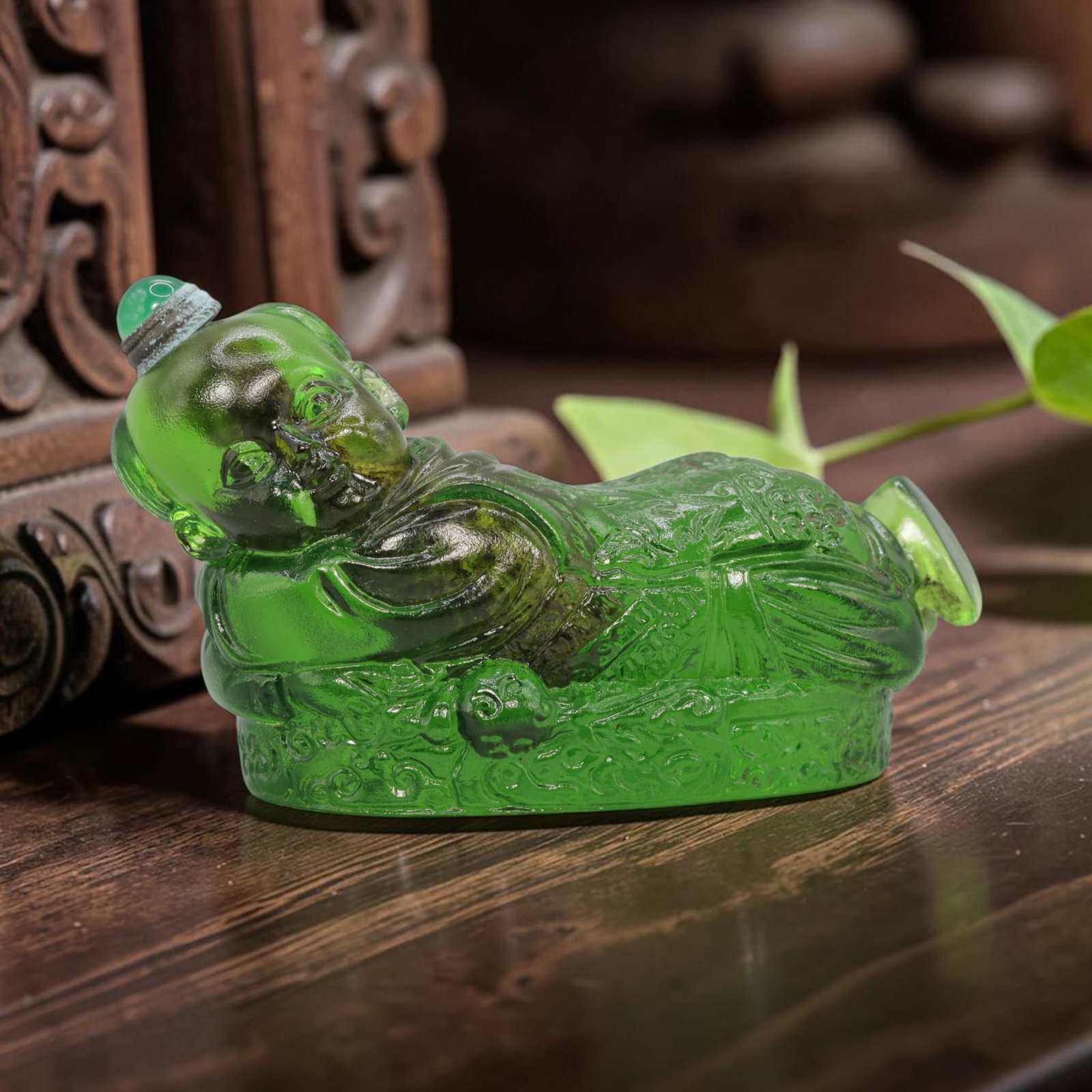 Vintage Chinese Green Liuli Glass Snuff Bottle - Reclining Child Figurine, 62YF: Crafted from translucent rich green liuli glass, this vintage Chinese snuff bottle is modelled as a reclining child figure. The glass exhibits a vibrant, saturated green hue with subtle tonal variatio