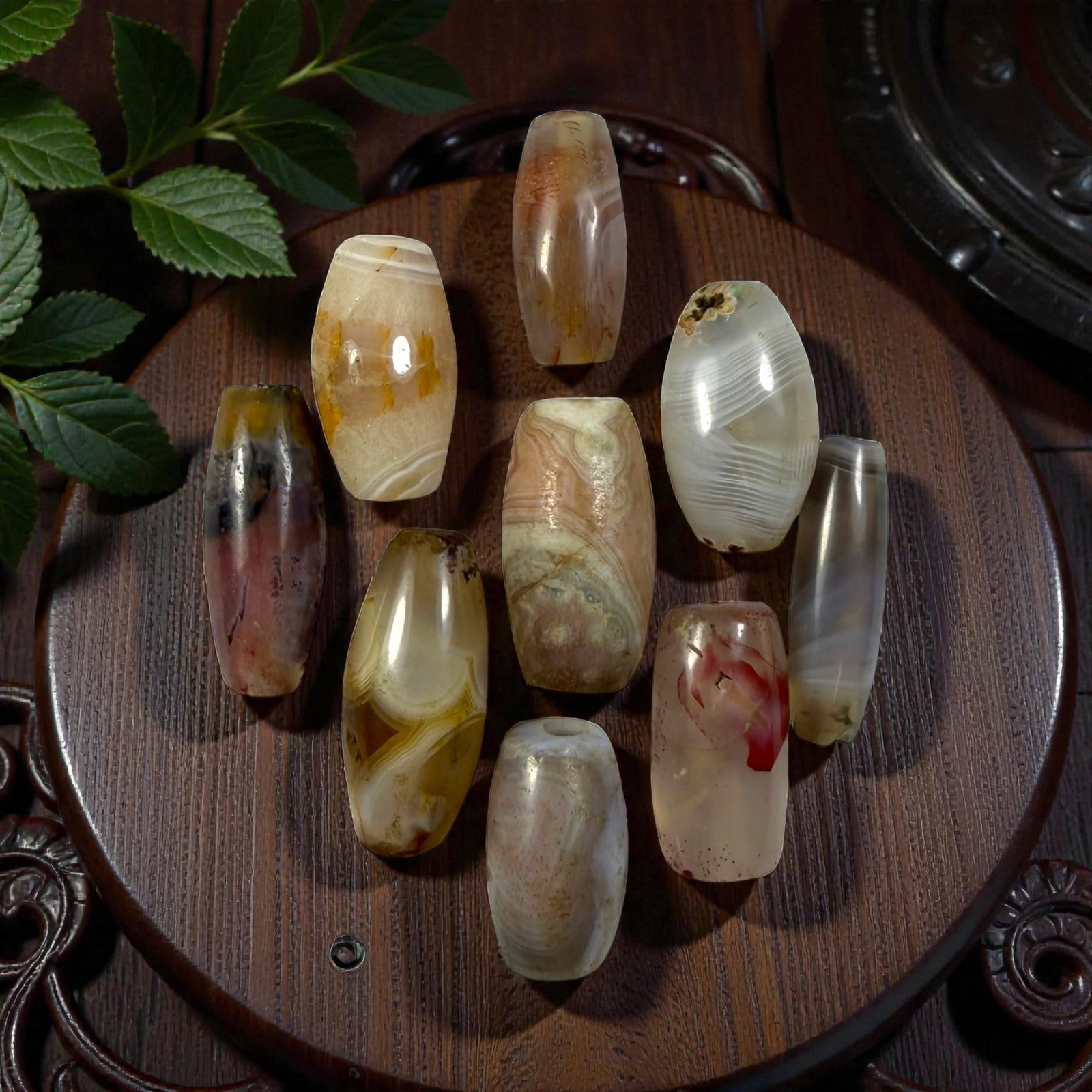 A Lot of 9 Himalayan Banded Agate Beads, Ancient to Antique Period, 19YD: Comprising lot of barrel and ovoid beads, each carved from banded agate with natural tonal variations, many displaying characteristic concentric, linear, and dendritic patterns. The surfaces exhibit s