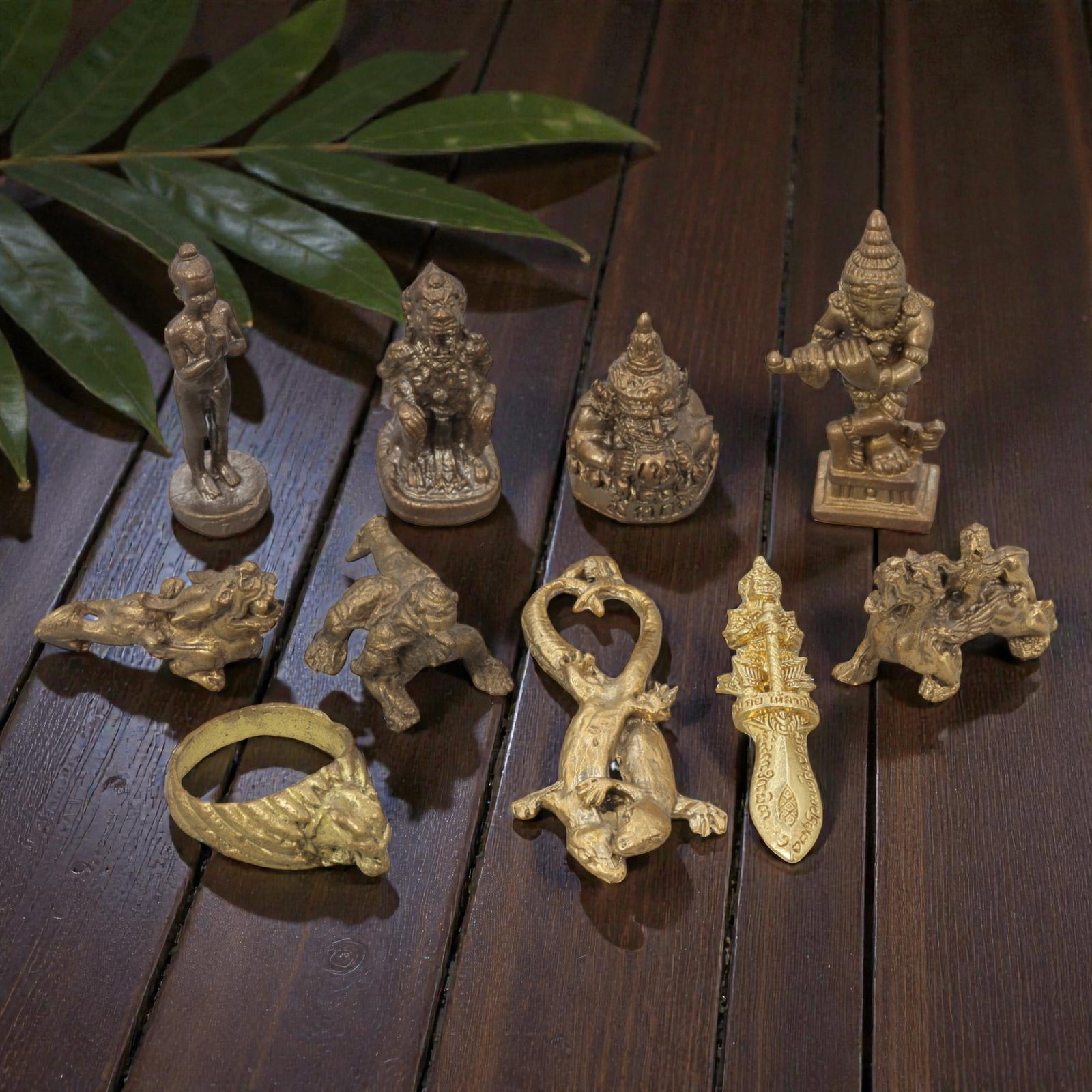 A Lot of 10 Vintage Southeast Asian Brass and Bronze Amulets and Figurines, 3WT: A curated lot of ten vintage Southeast Asian amulets and figurines, crafted from brass and bronze with varied patinas and finishes. The collection includes devotional deity figures, guardian and mythi