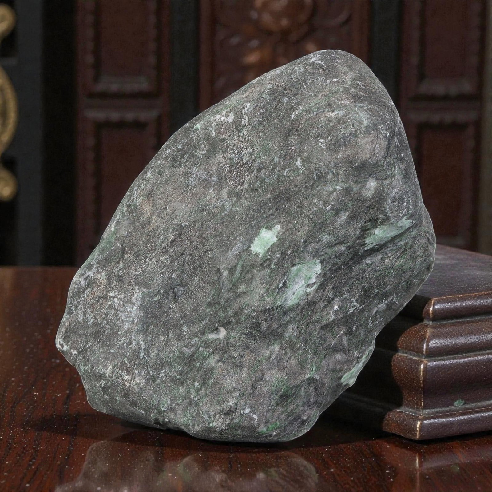 870Ct Natural Type A Burmese Jadeite Jade Rough Stone - Green Raw Material, 8ZB: Natural Type A Burmese jadeite rough stone, displaying scattered light green mineral deposits visible through its thick, naturally weathered dark grey outer skin. The stone retains its uncut, naturall
