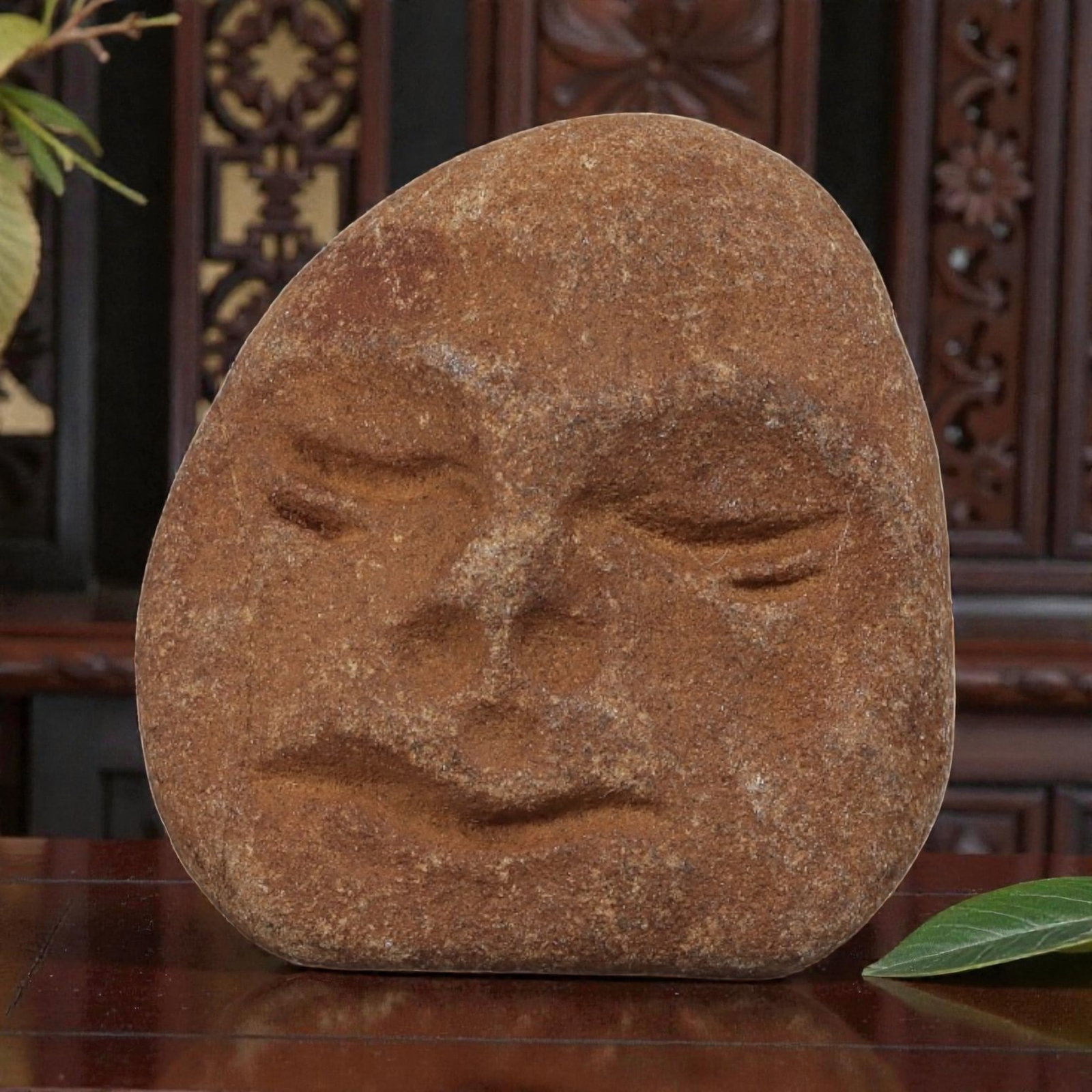 Antique Medieval Carved Stone Maskette, 82AN: Carved from a single piece of weathered brown stone, this maskette depicts a stylized human face in relief. The figure features simplified, closed eyes, a prominent nose, and subtle lips, with the sto