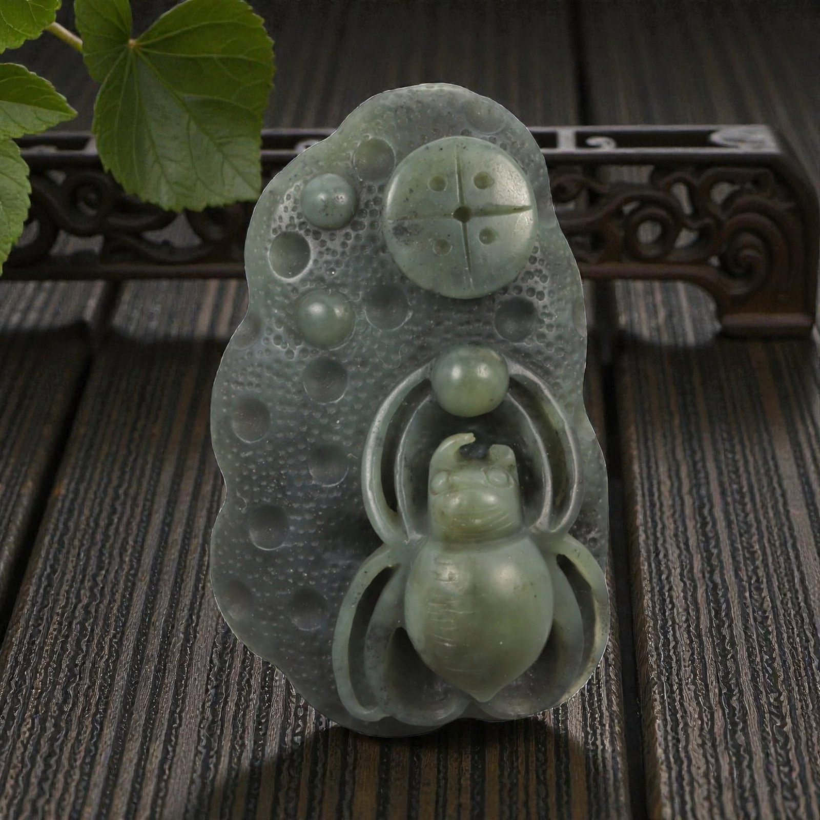 Natural Hetian Nephrite Jade Spider Pendant, 20th Century, 13FB: Carved from translucent green jade with darker mottling and natural inclusions, the plaque is worked in low relief with a spider shown frontally, its rounded abdomen and segmented body rendered with s