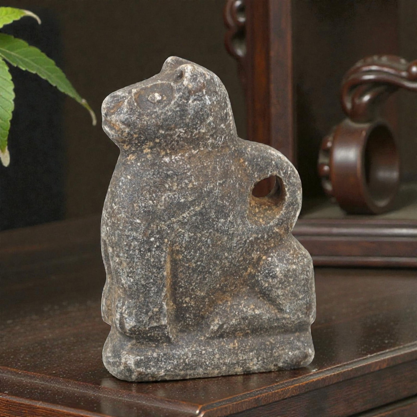 Ancient Stone Zoomorphic Amulet - Near Eastern Animal Figure, 3AM: This amulet is carved from dark speckled stone, depicting a stylized quadrupedal animal in a seated posture, with incised linear detailing defining the facial features, ears, and limbs. The piece refl